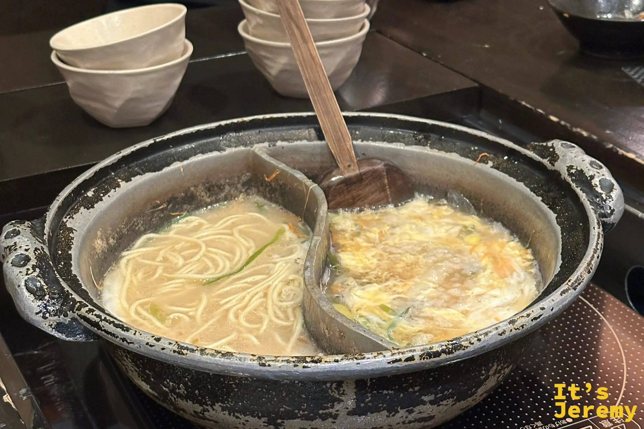陰陽鍋的收尾：左邊是吸滿白湯的麵條，右邊是打了蛋花的雑炊粥，木杓插在中間