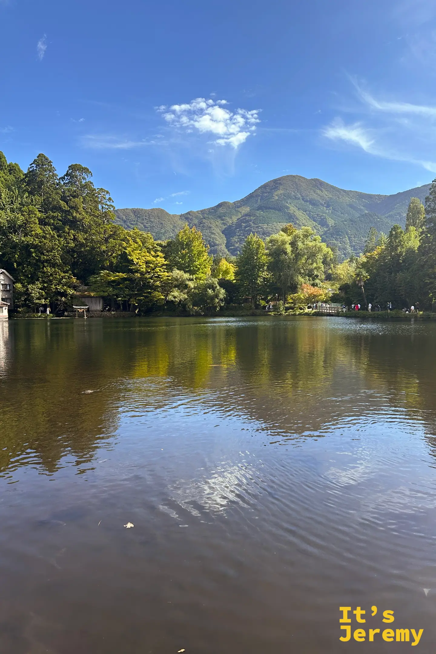 金鱗湖另一角度的湖景，湖畔木造旅館與遠方山脈倒映水中