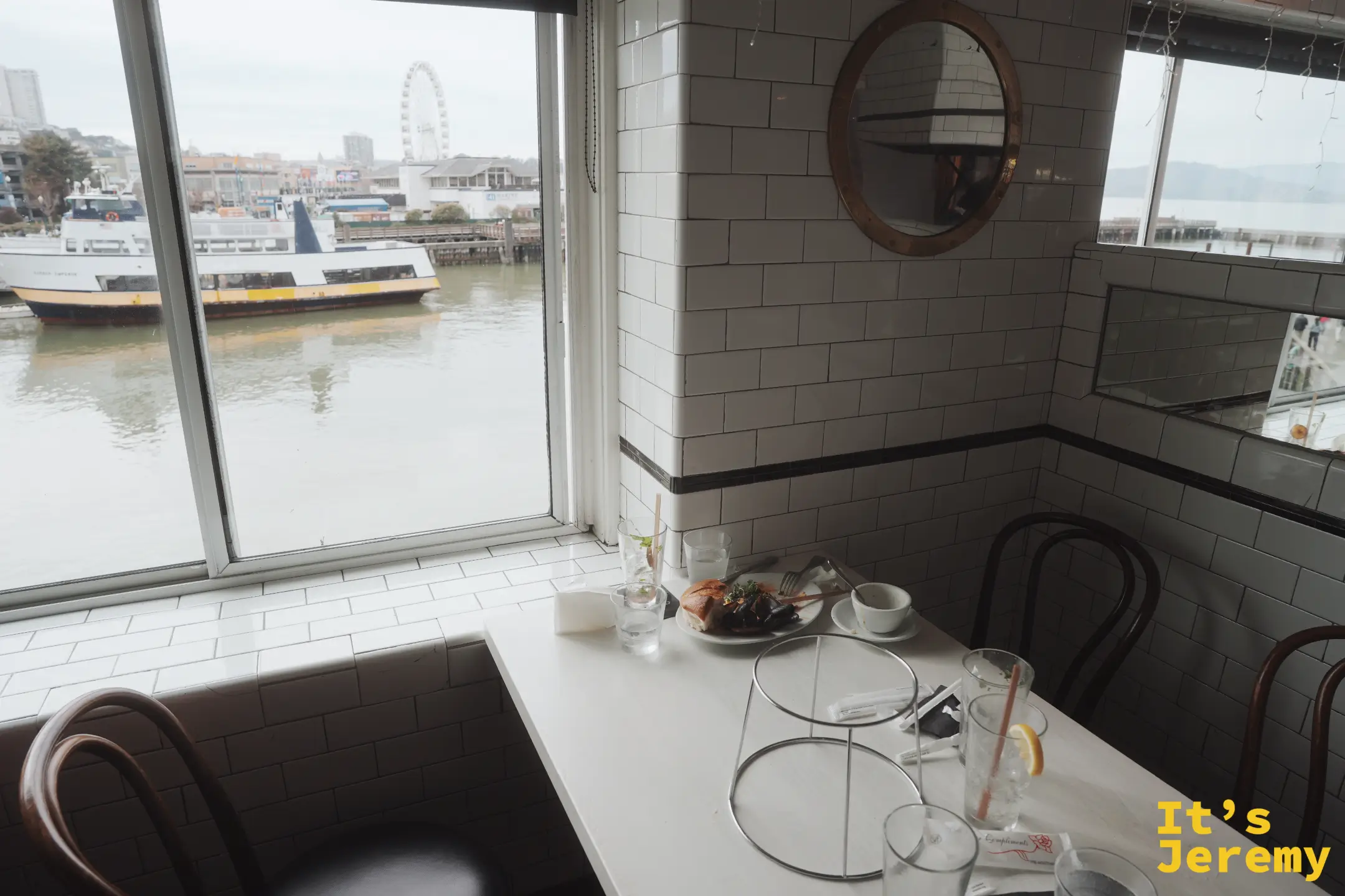 Crab House 靠窗座位望出去的海灣景色，一艘渡輪正經過，遠處是摩天輪與 PIER 41 海事碼頭