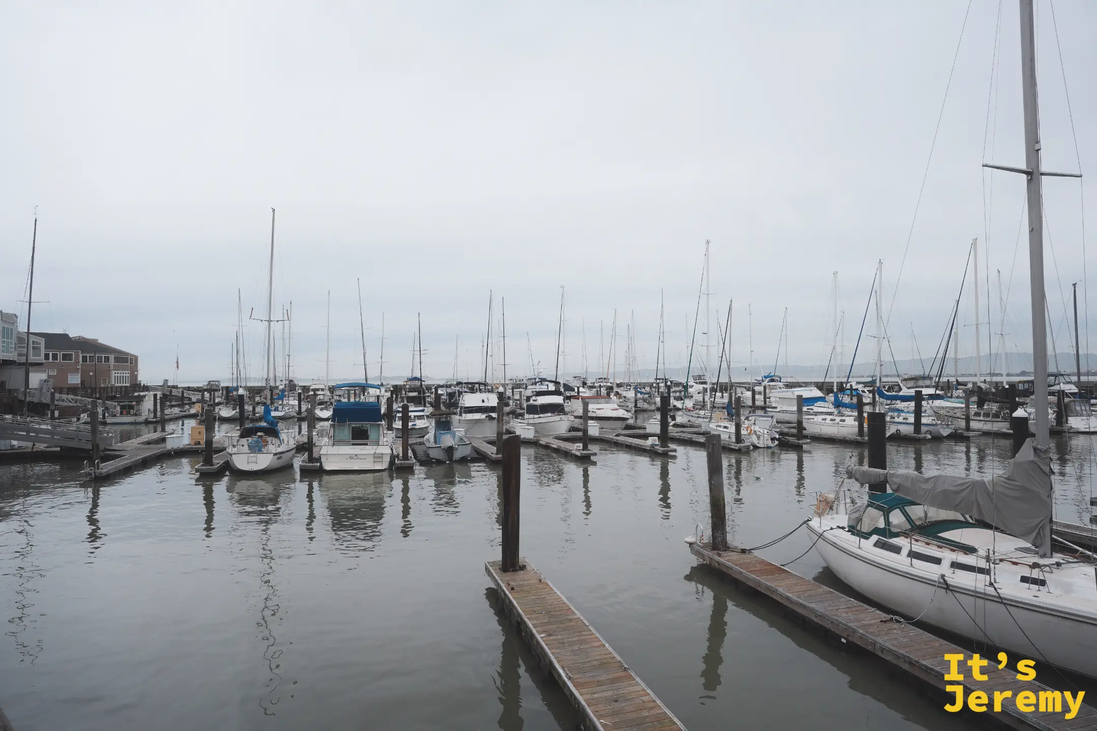 PIER 39 旁停滿帆船與遊艇的碼頭，成排桅杆在陰天下靜靜排列