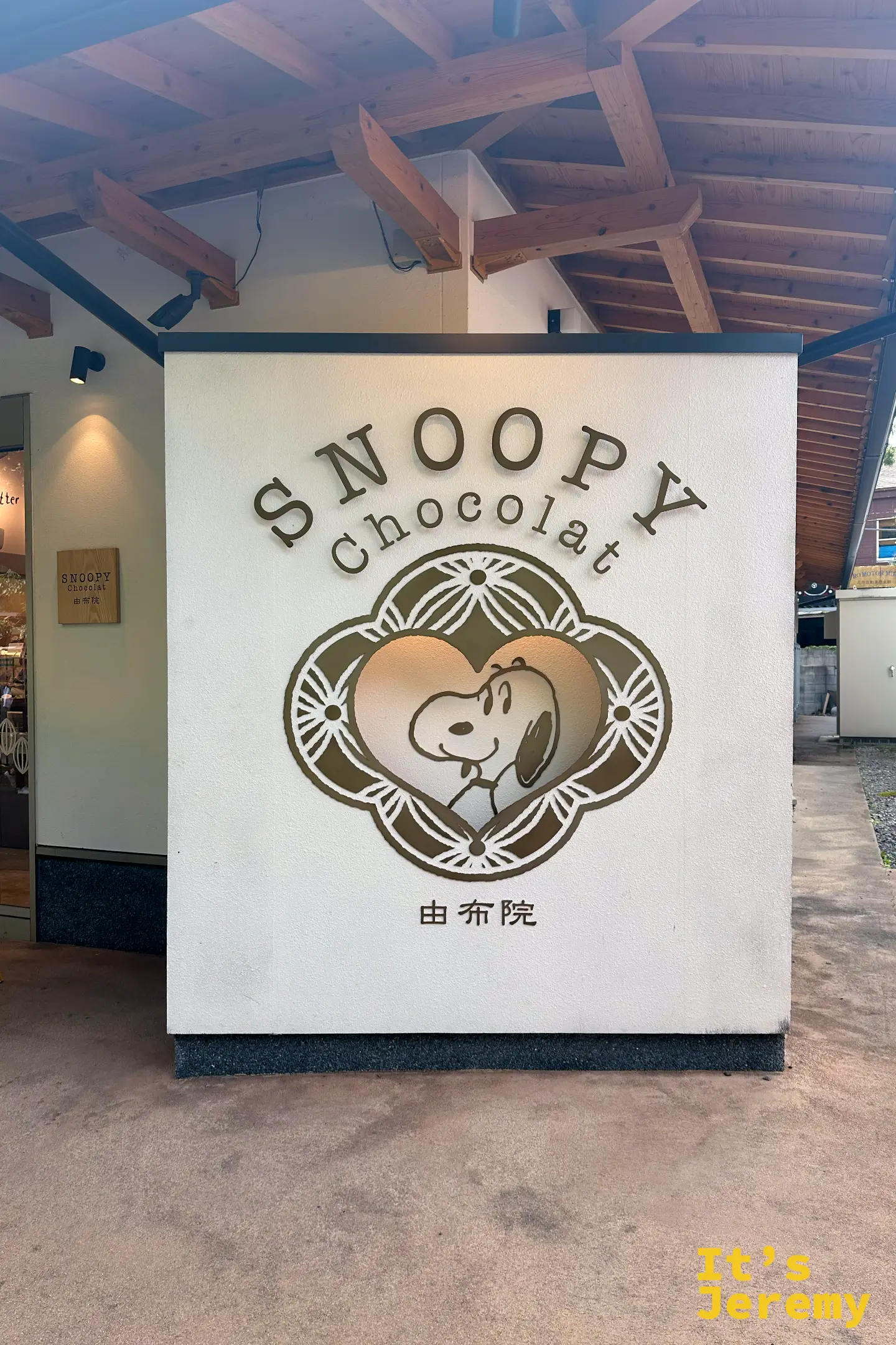 SNOOPY Chocolat 由布院店的白牆招牌，中央是史努比愛心 logo