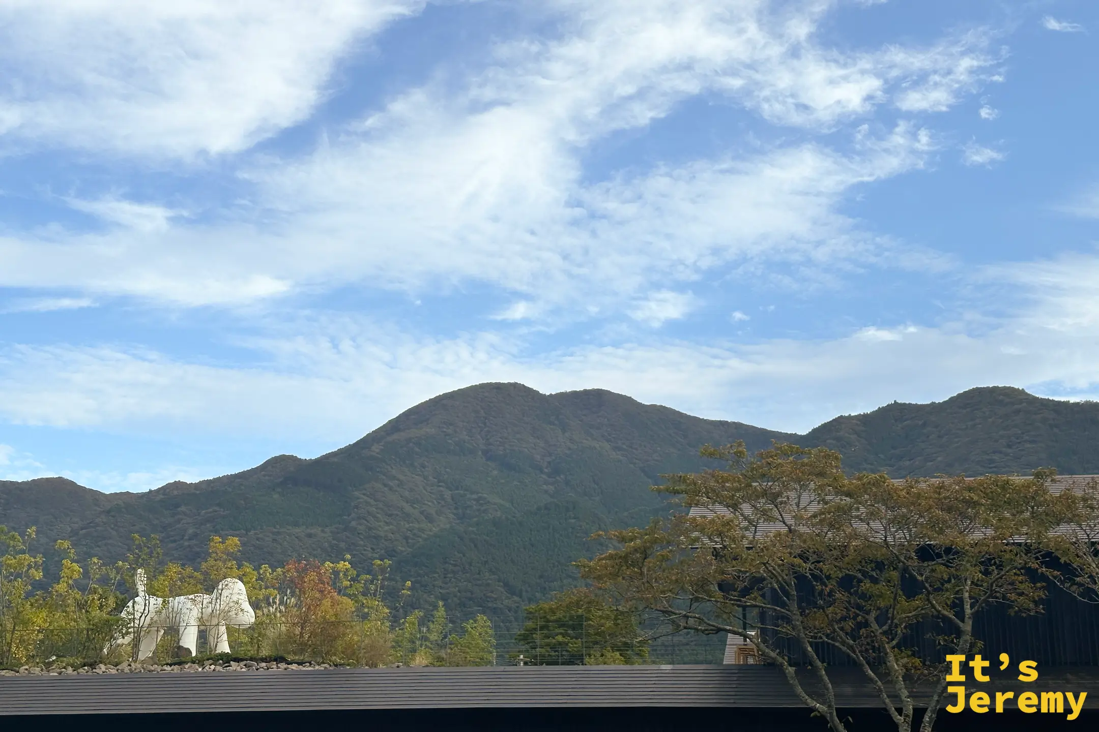 白色大狗雕塑與背後連綿的由布院群山
