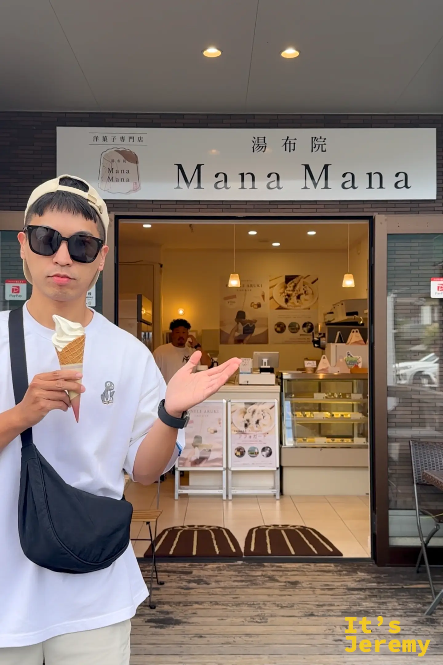 Jeremy 站在湯布院 Mana Mana 店前，手拿一支北海道霜淇淋比手勢