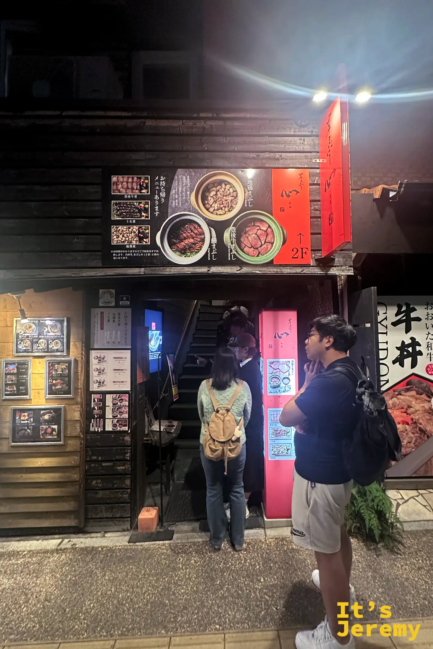 店門口的樓梯與菜單牆，客人正排隊看菜單準備上二樓