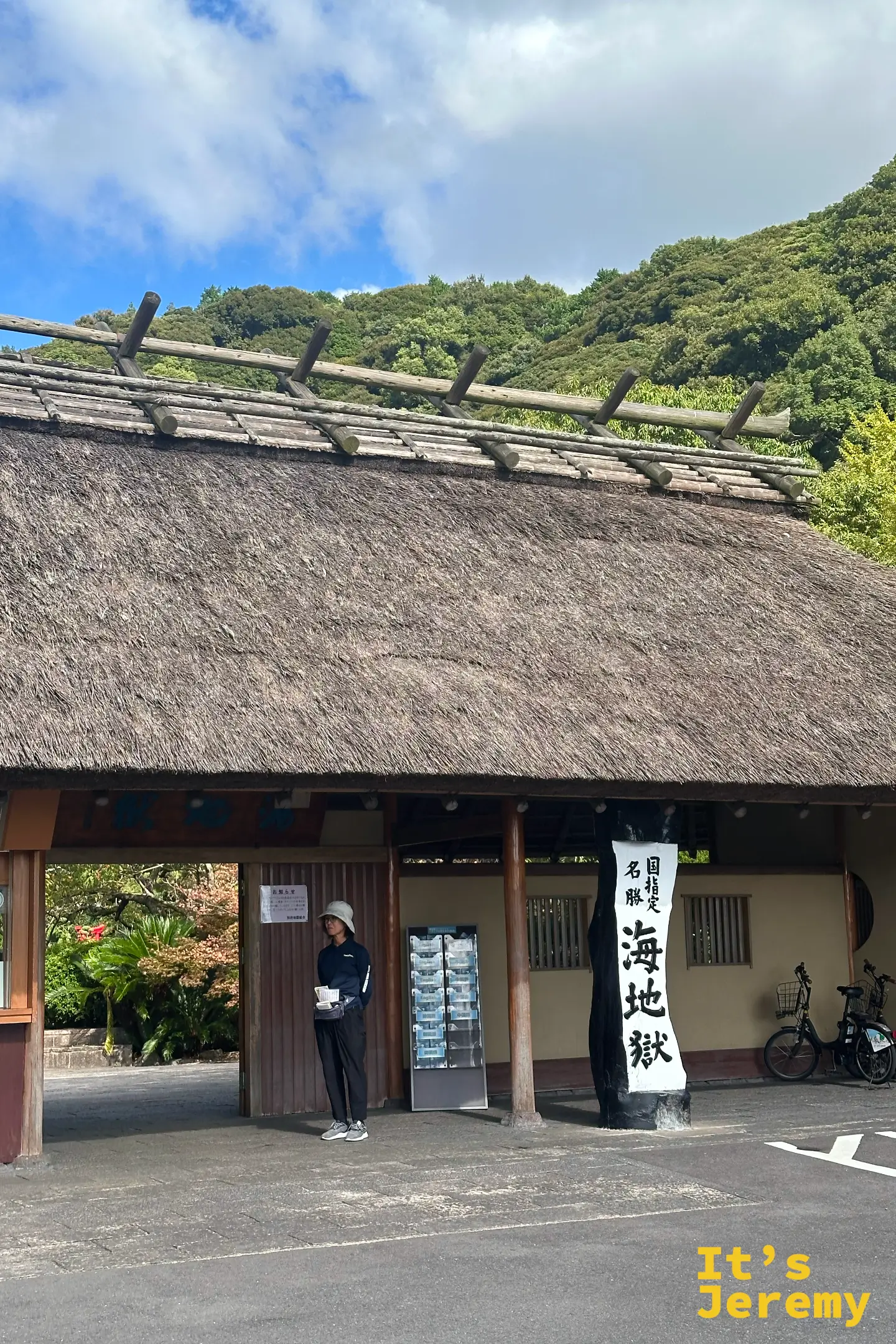海地獄茅草屋頂的售票口入口，掛著「国指定名勝 海地獄」的黑底白字木牌