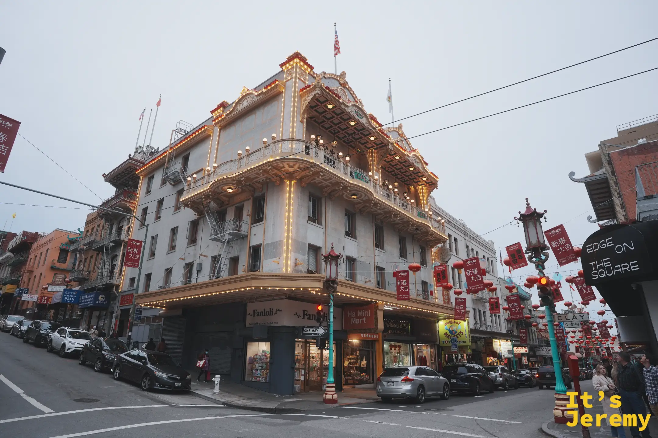 街角一棟以整排燈泡勾勒飛簷立面的華麗老建築，入夜點亮後金光閃閃，樓下是商店與紅色寶塔路燈