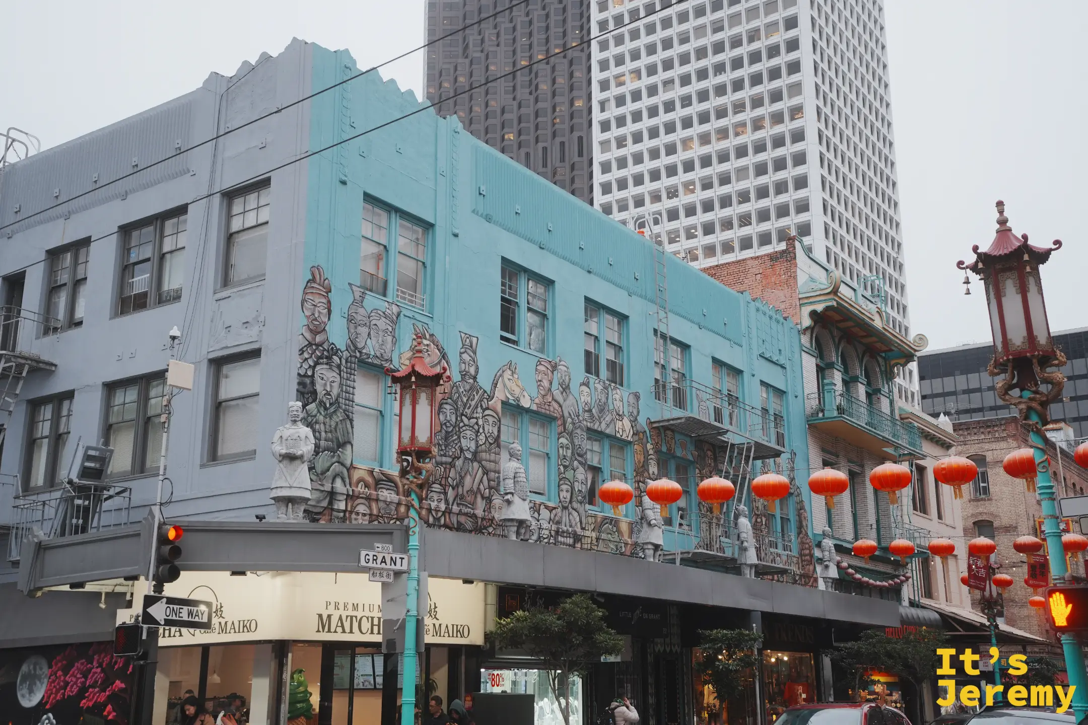 Grant 街口一棟藍綠色建築的外牆繪滿兵馬俑壁畫，紅色寶塔路燈立在前方，一旁掛著紅燈籠