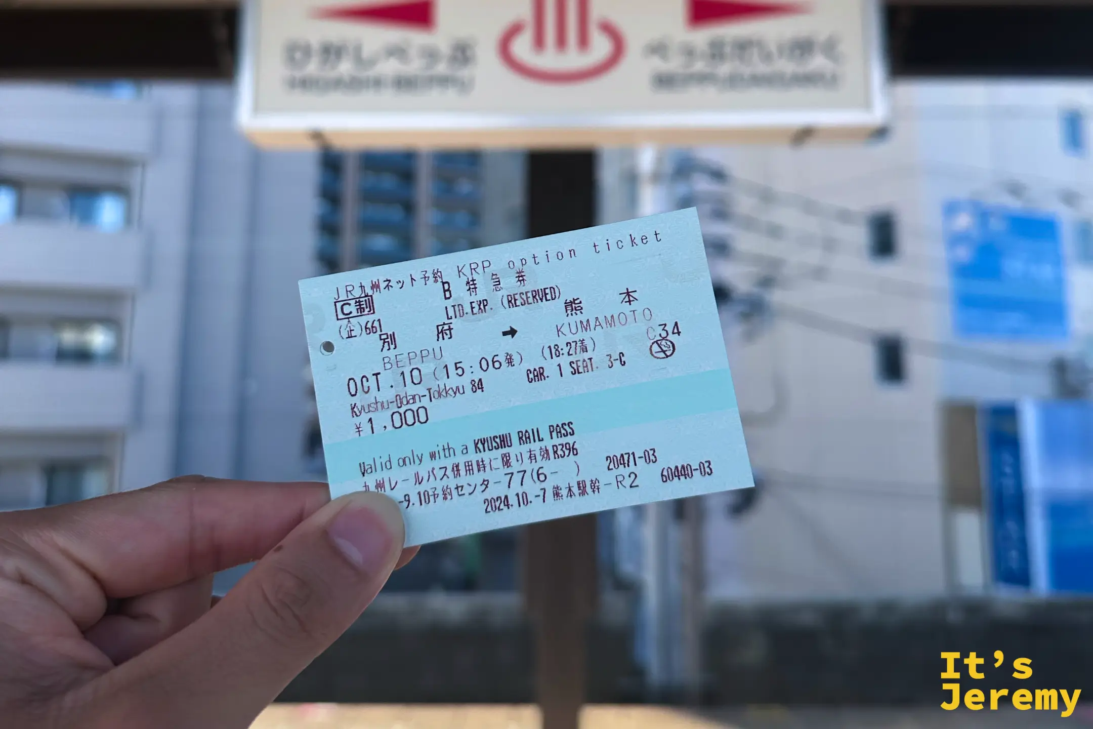 手裡拿著一張綠色的 JR 特急券，標示別府到熊本區間