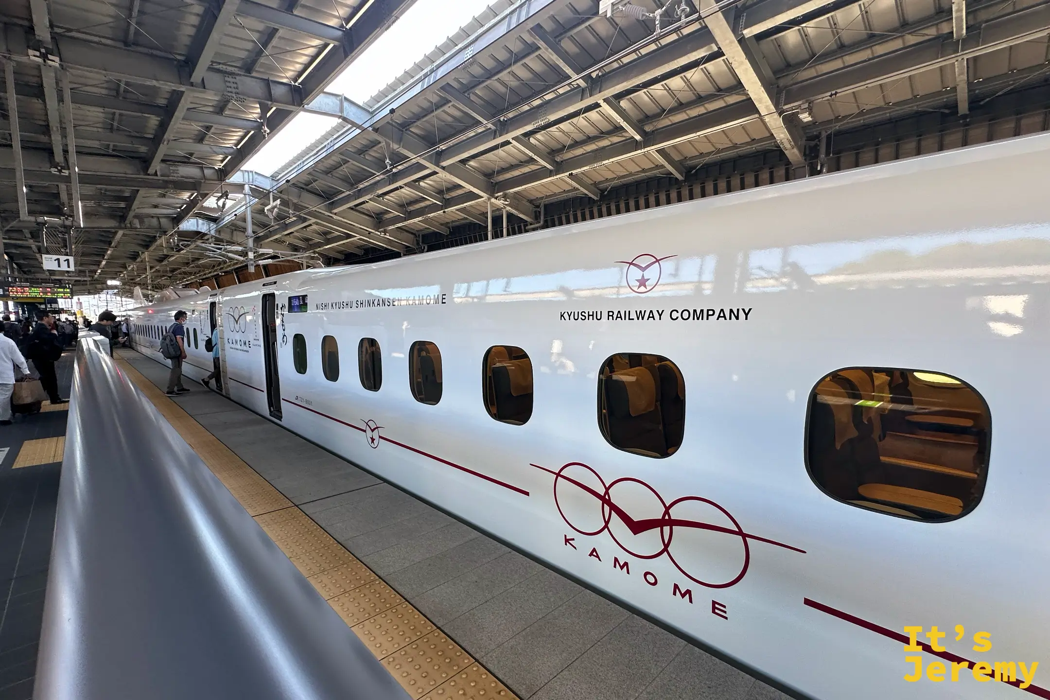 西九州新幹線かもめ列車停靠月台，白色車身配紅色 KAMOME 標誌，車門開啟