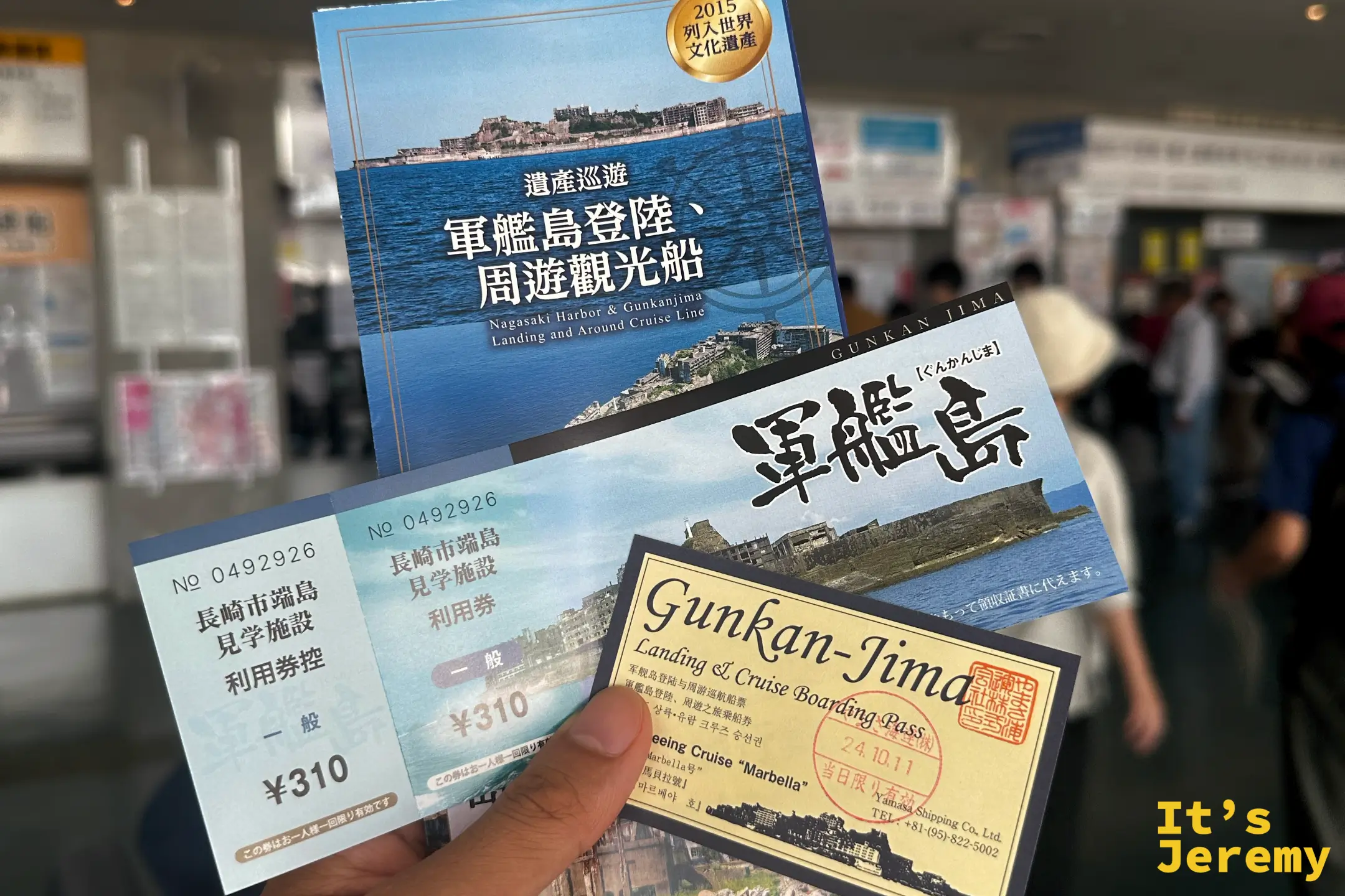 手拿軍艦島登島船票與端島見学施設利用券等票券