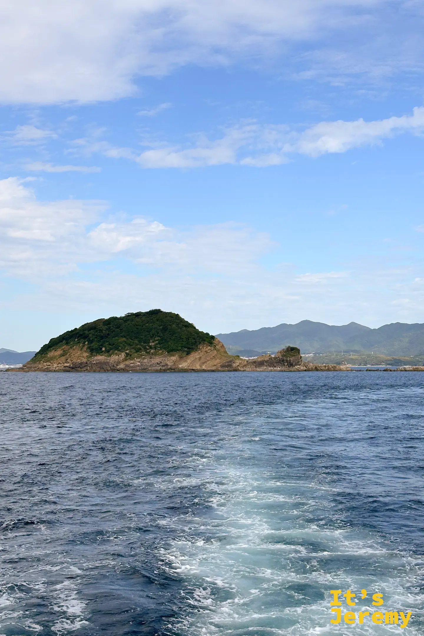 船行外海，經過一座覆滿綠意的無人小島