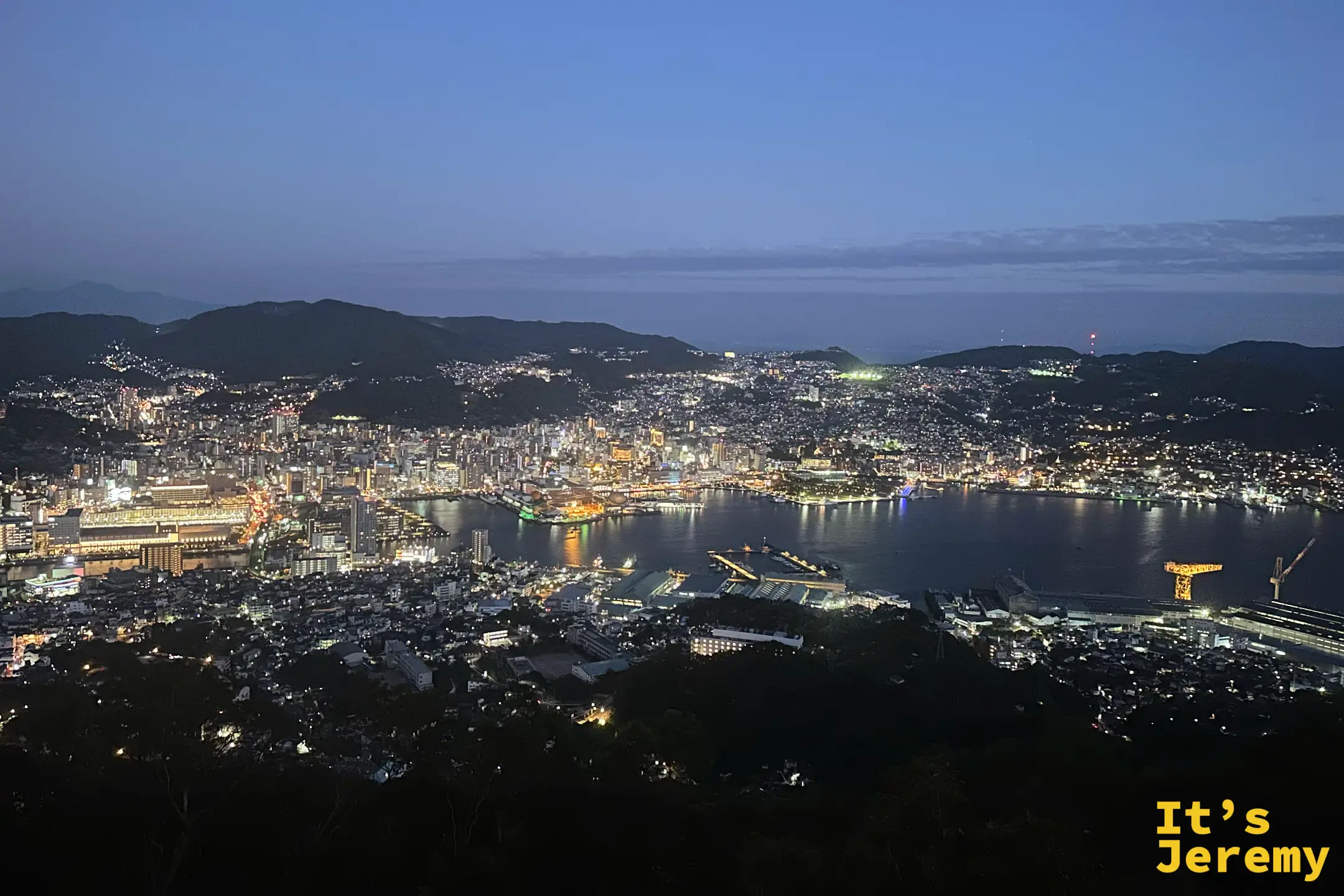 稲佐山俯瞰長崎的夜景，市中心與港灣兩岸的燈火沿著山坡層層鋪開