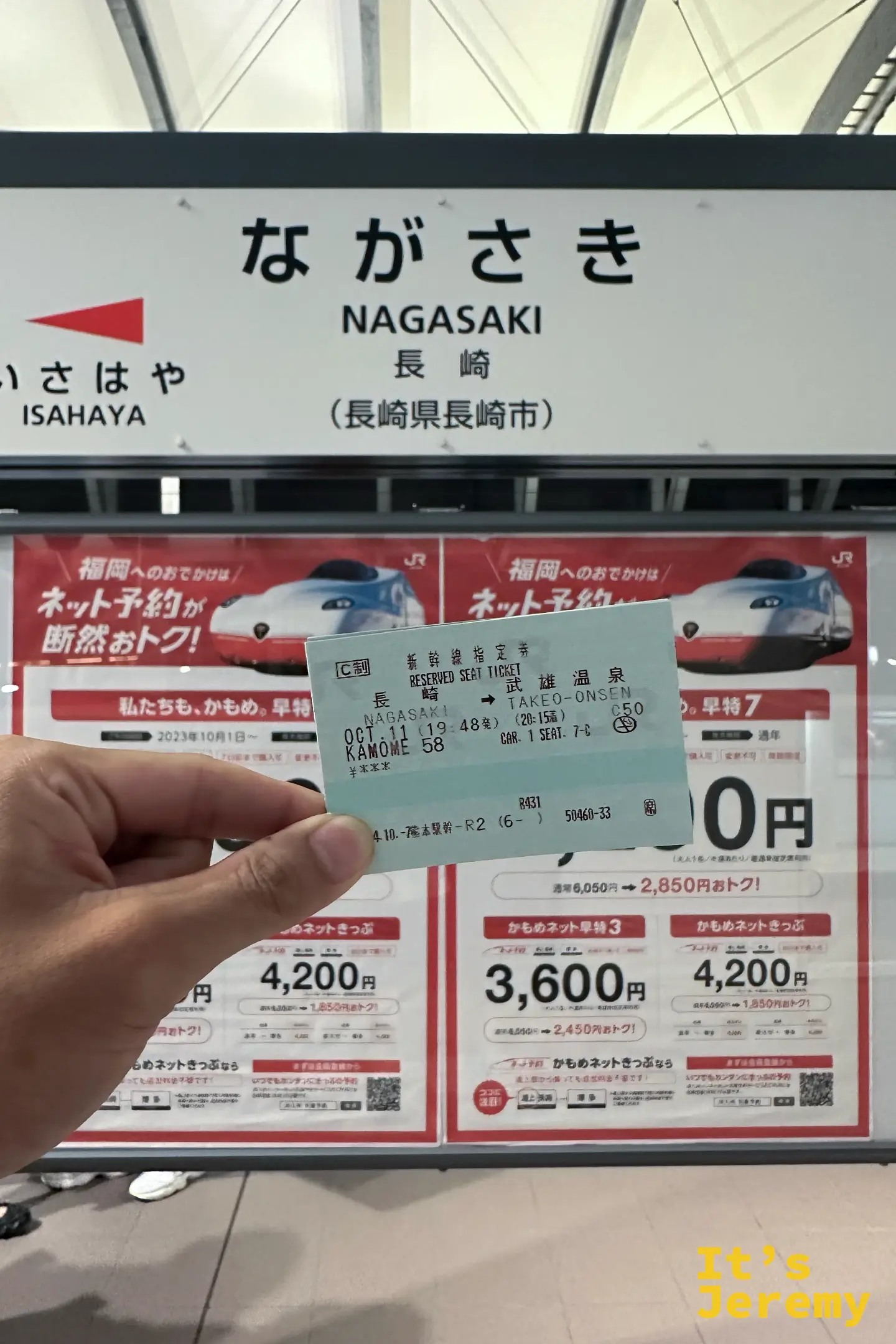 手拿指定席券，長崎往武雄溫泉，站在ながさき NAGASAKI 站名牌前，背後是かもめ的宣傳海報