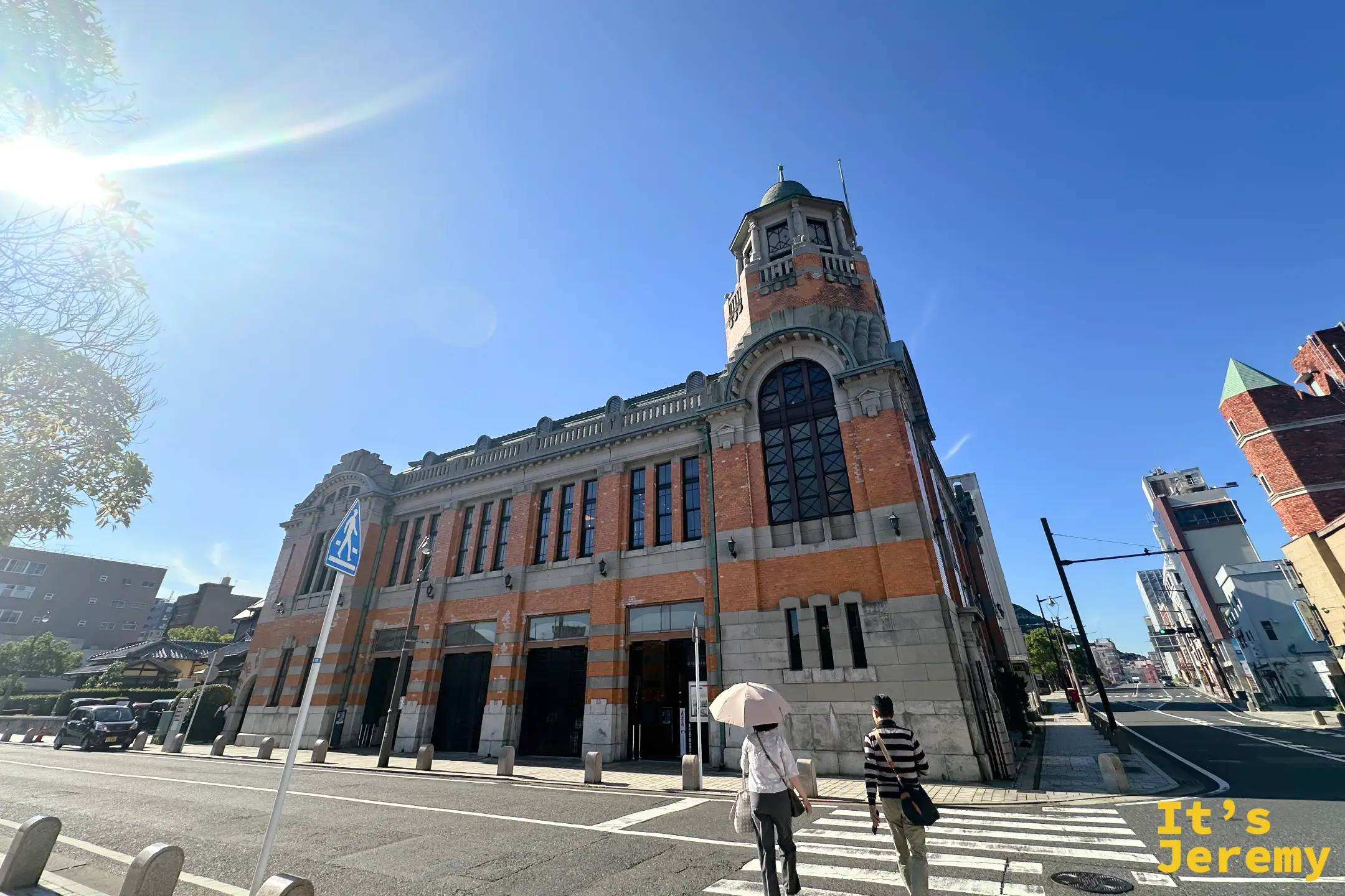從門司港街道遠望舊大阪商船大樓,紅磚建築與前方馬路構成典型的北九州門司港懷舊區街景