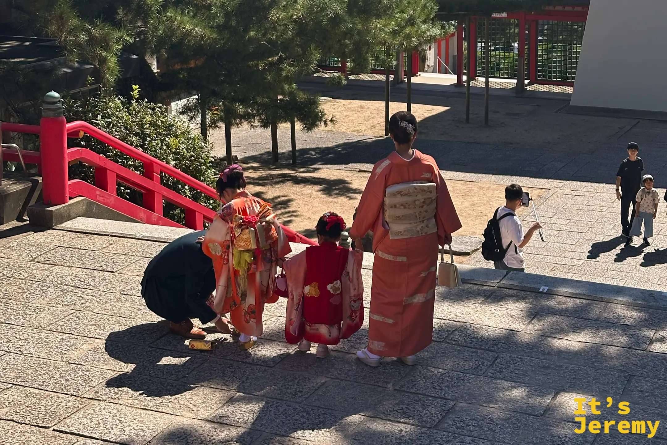 一個家庭在下關赤間神宮慶祝七五三節,母親正為穿著華麗和服的女兒整理儀容
