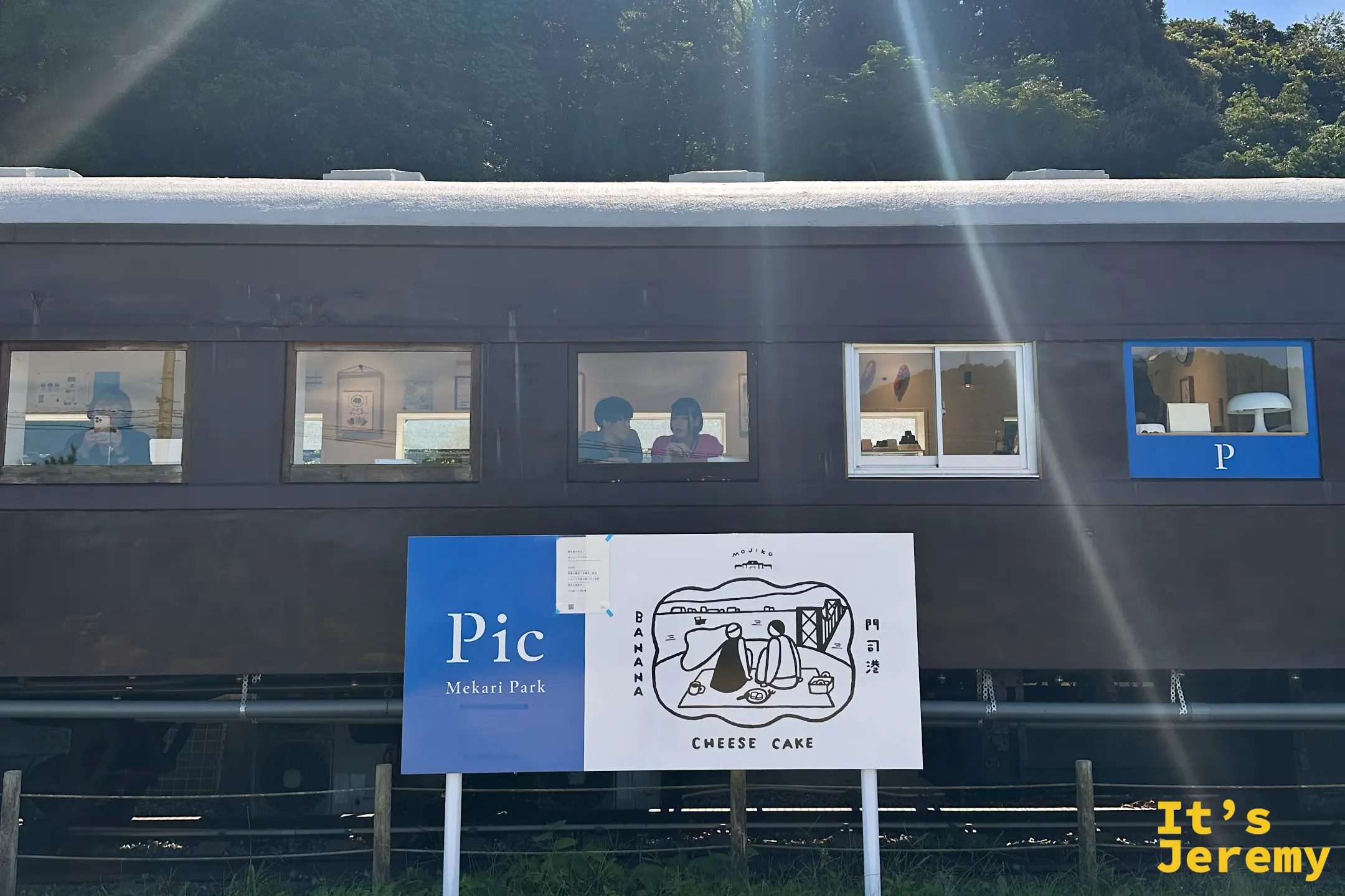 近距離特寫福岡門司「Pic」咖啡廳，透過復古火車車廂窗戶可見到遊客在內用餐，展現出門司港特有的懷舊與悠閒氛圍