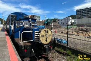 停靠在關門海峽めかり駅月台的潮風號觀光列車橫式全景，這裡是北九州銀行レトロライン最受歡迎的景點停靠站