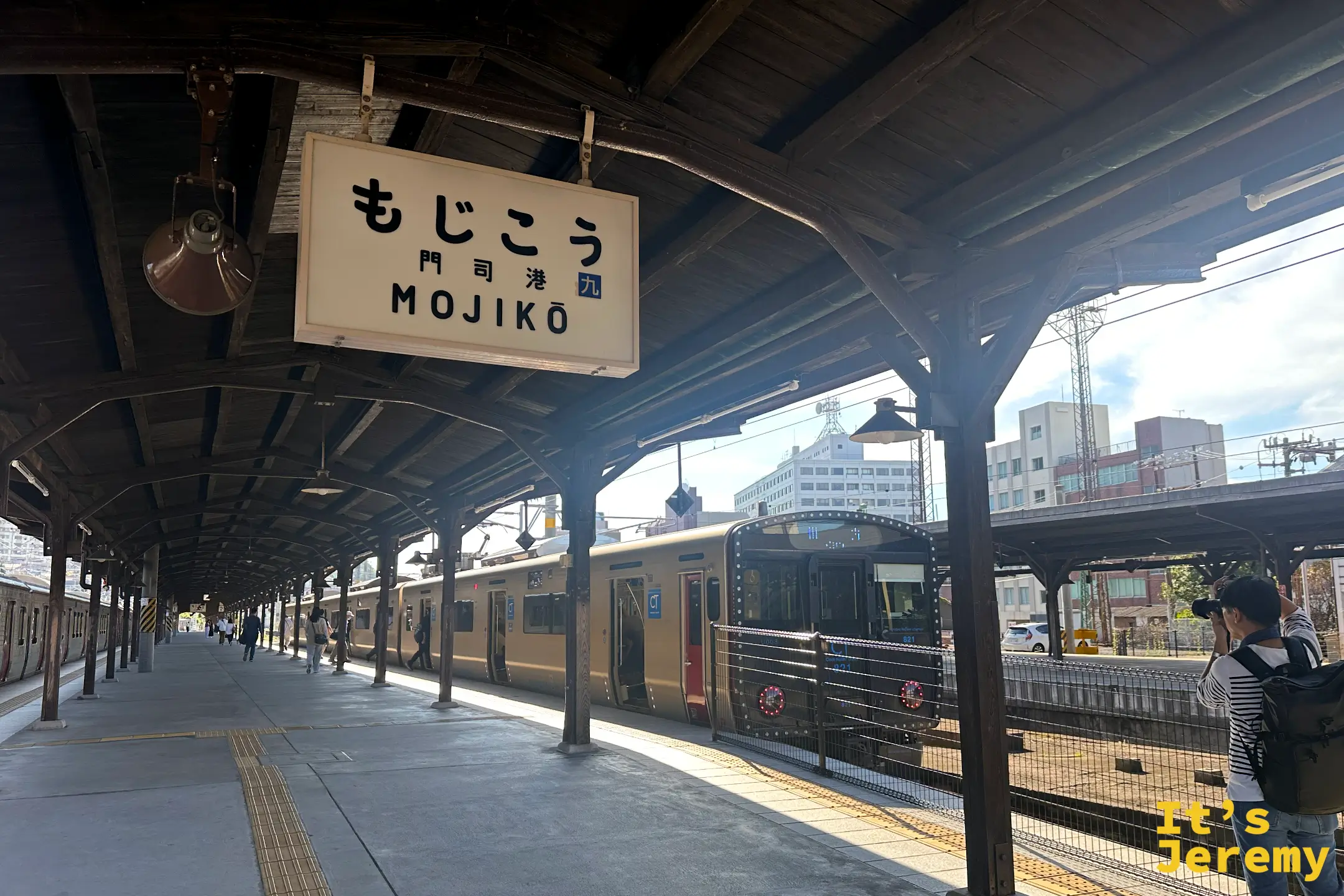 停靠在門司港車站月台的 JR 九州通勤型電車,復古車站與現代列車交會出獨特的時代感