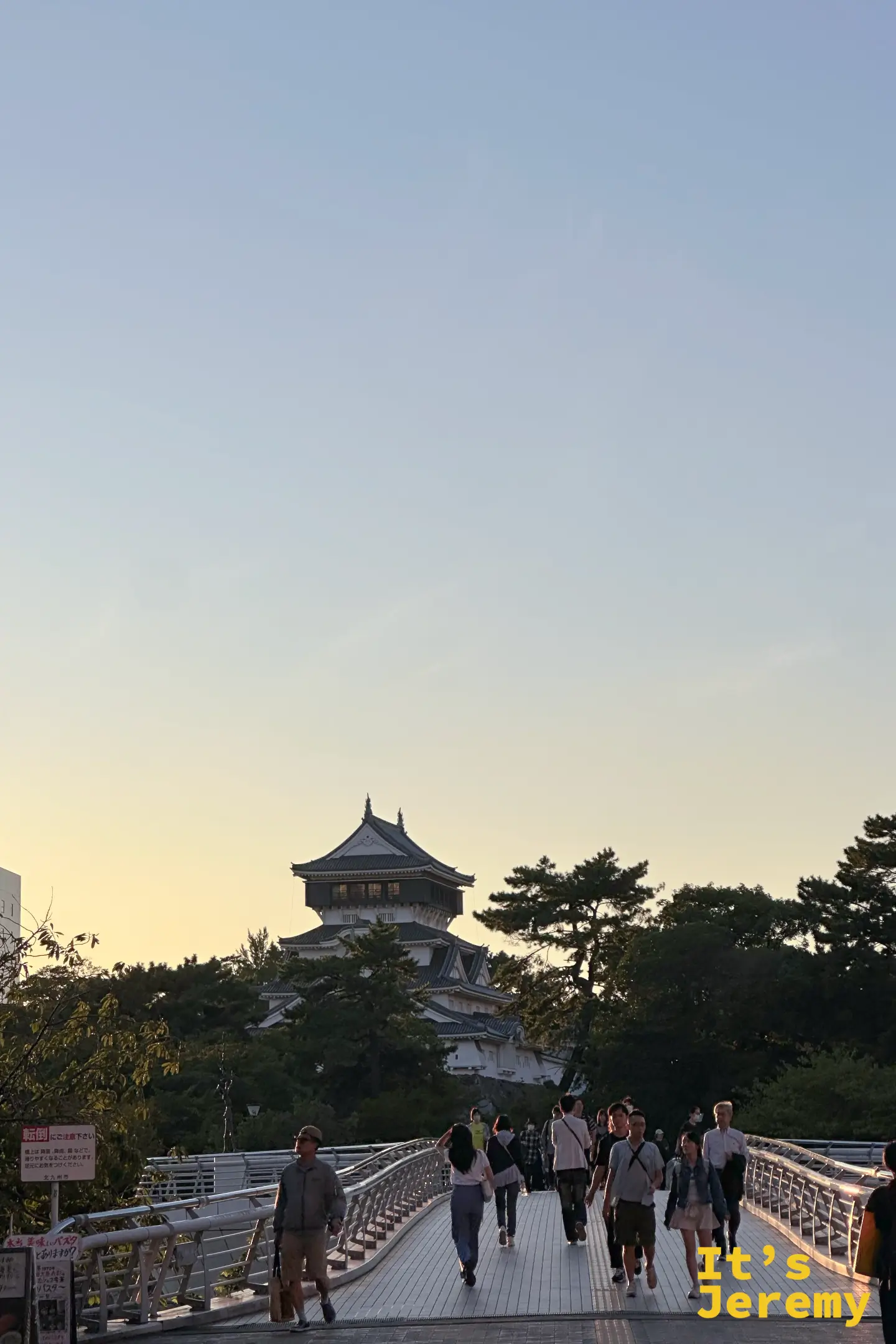 夕陽餘暉映照在小倉城天守閣,從路面橋上拍攝的寧靜視角