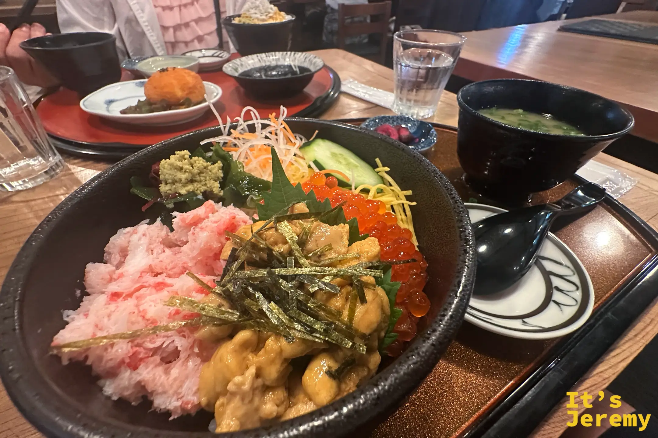 天草海まる的豪華三色丼特寫,海膽、鮭魚卵與蟹肉鮮豔誘人