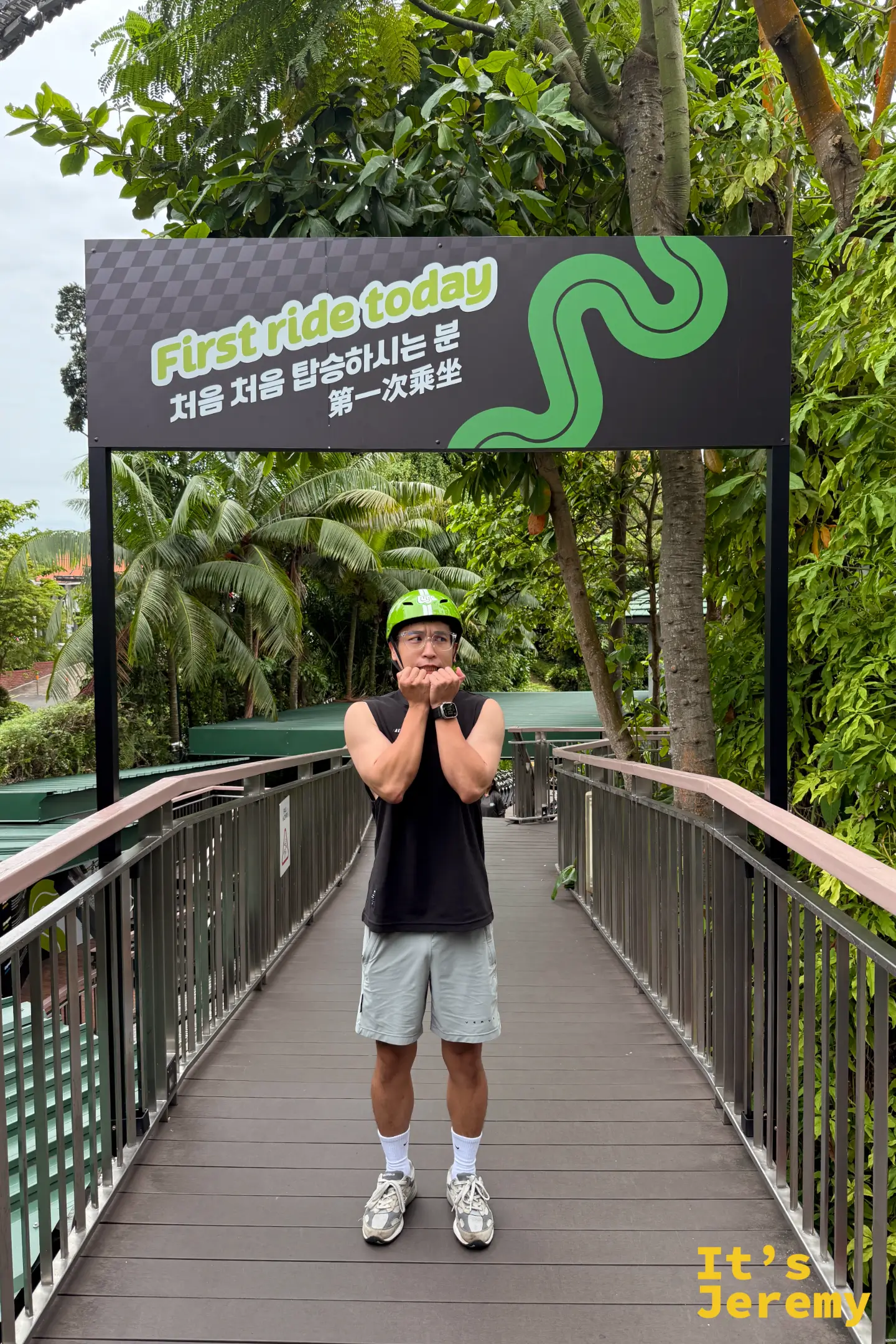 遊客戴著綠色安全帽，在通往 Skyride 空中吊椅的木棧橋合影，後方有 Kupu Kupu Trail 賽道的指標牌