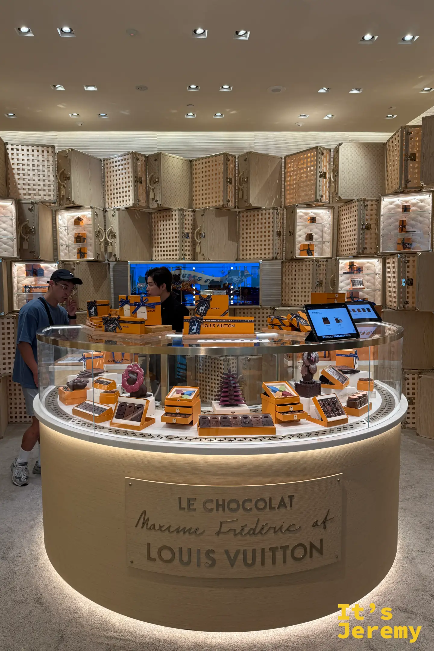 LV 水晶島巧克力店中央的波浪型冷藏櫃，如陳列珠寶般展示 Vivienne 音樂盒與 Petula 造型巧克力