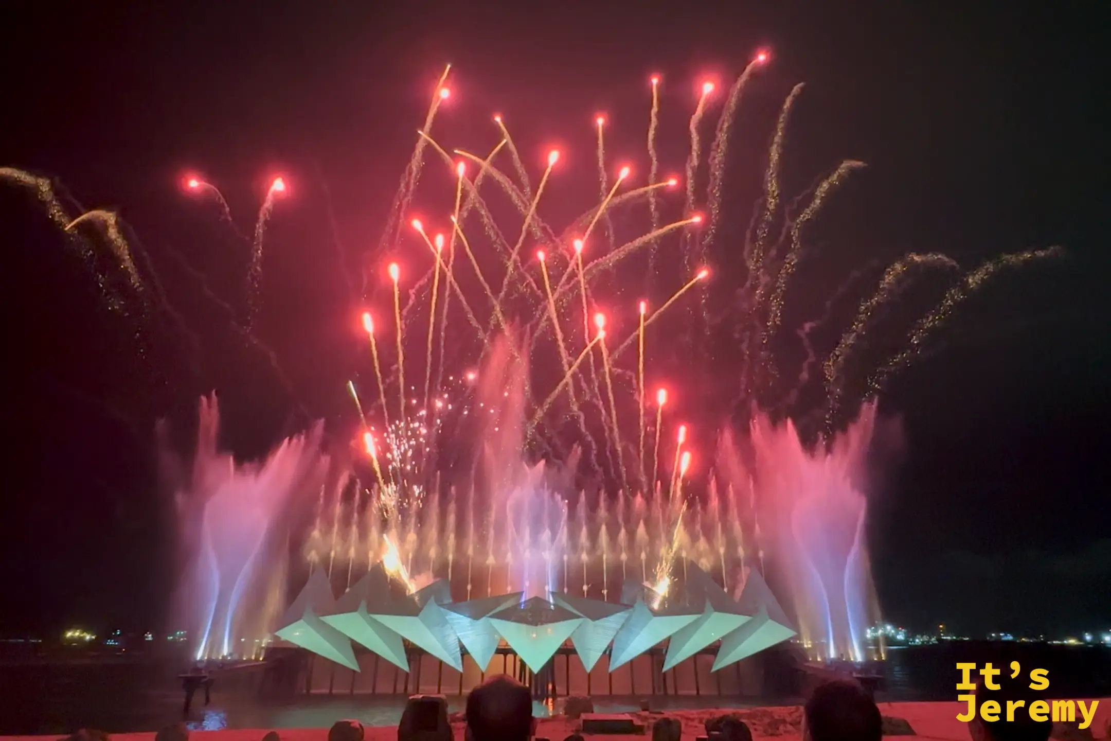 時光之翼壓軸的煙火交響曲，高空煙火、粉紅火光與海上噴泉同步