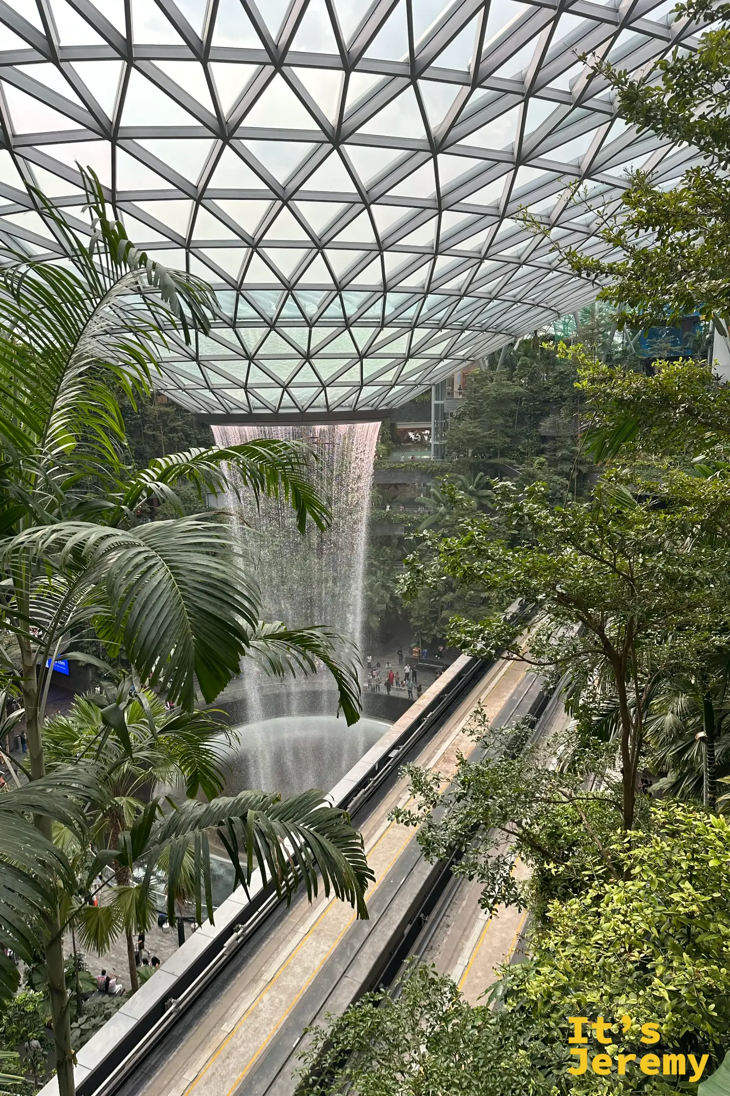 從資生堂森林谷綠色植物步道遠眺室內巨型瀑布,圓頂玻璃溫和採光