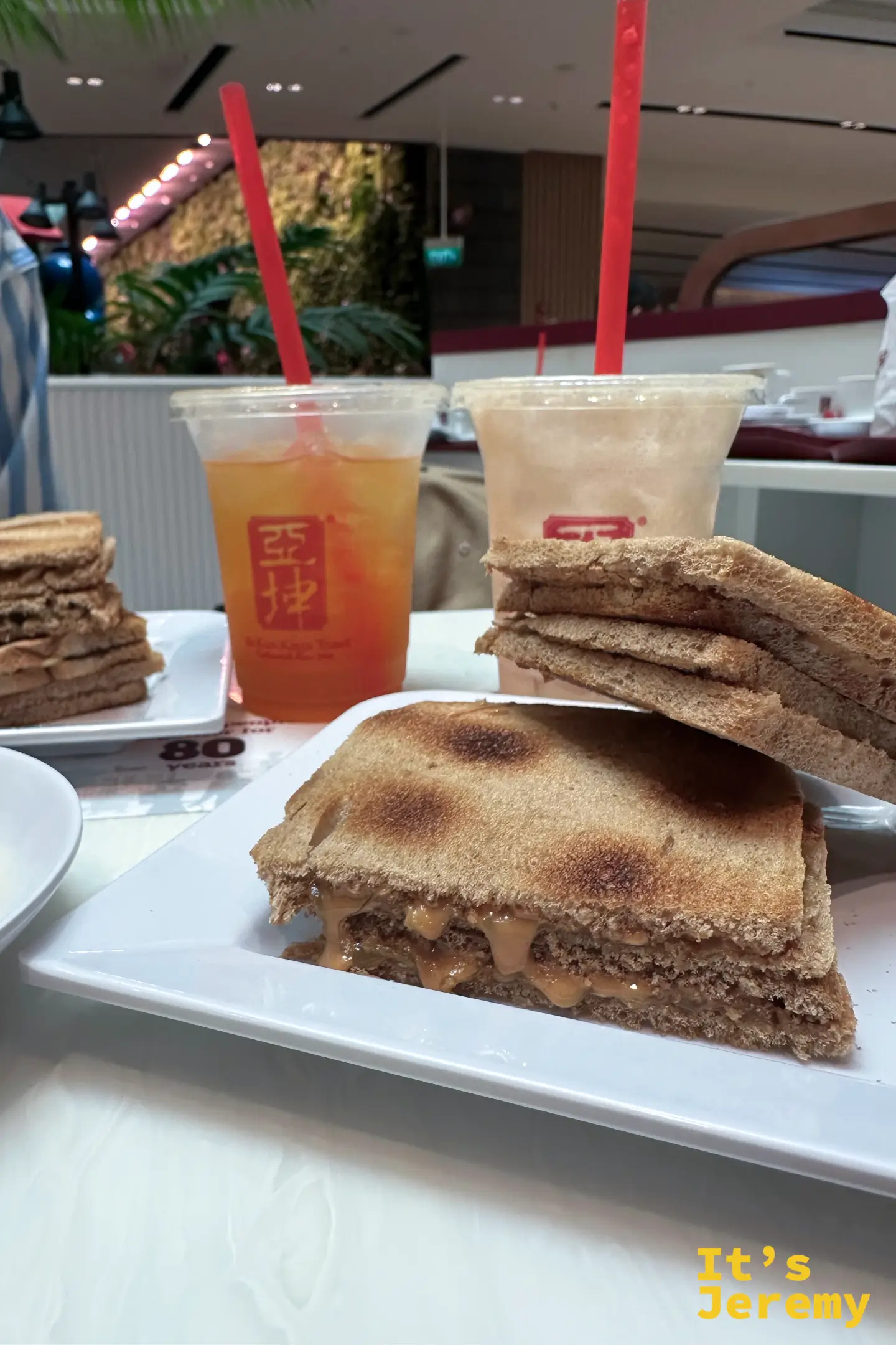亞坤招牌炭烤褐色吐司近景，夾著咖椰醬與厚切牛油片