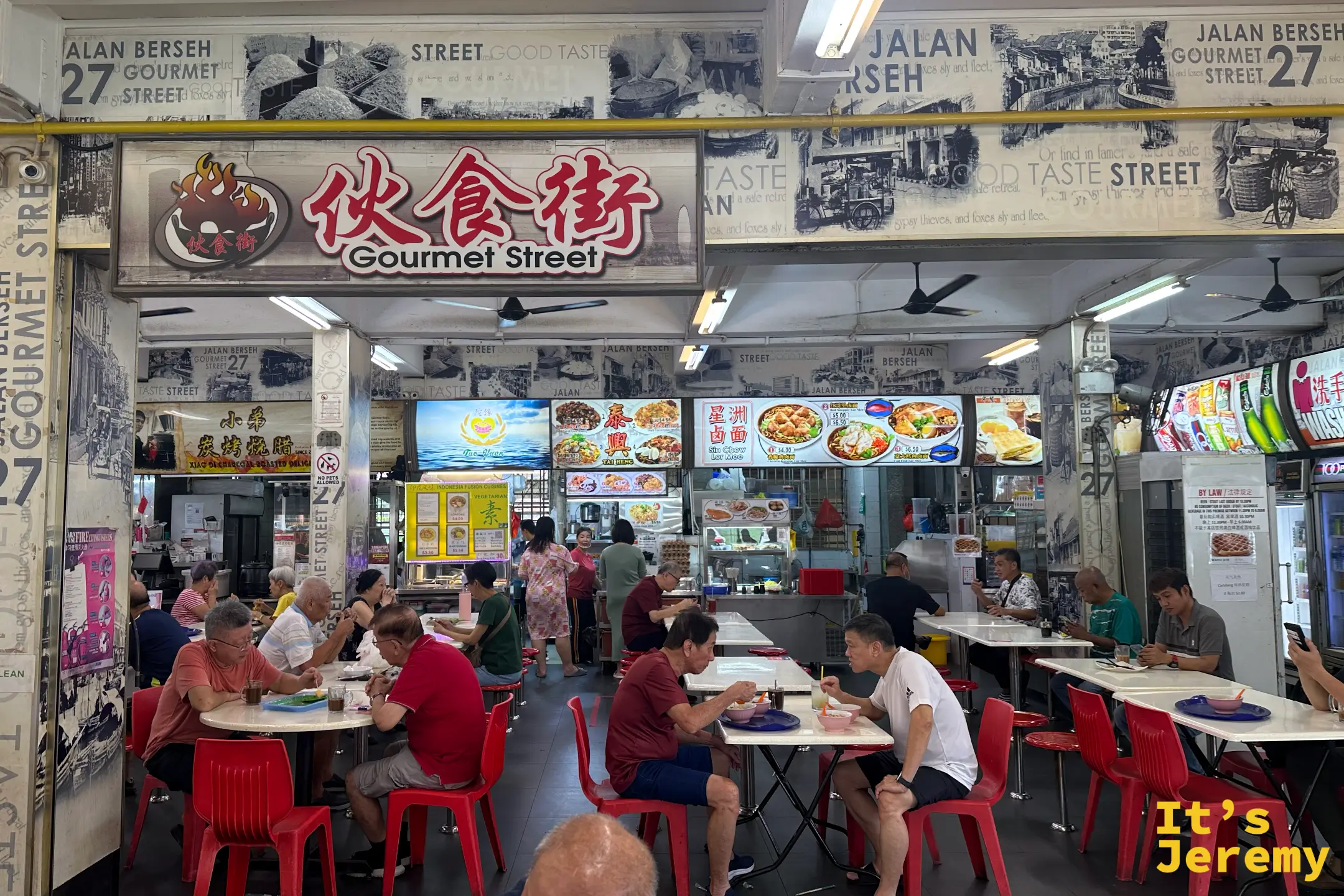 遠眺 27 Jalan Berseh 咖啡店內的結霜橋叻沙黃色招牌，門前有在地熟客點餐