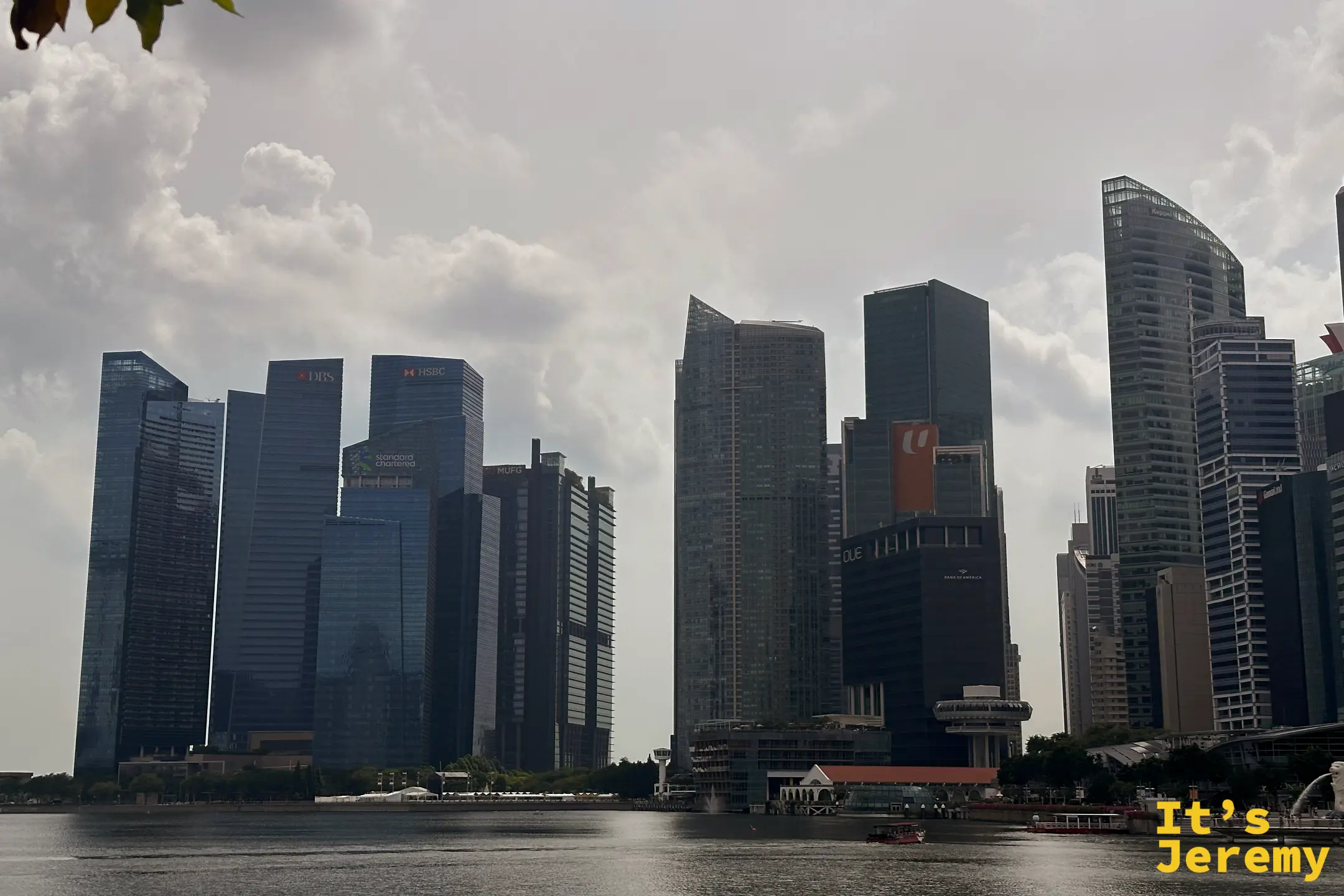 從海濱長廊向金融區方向延伸,高聳入雲的鋼骨玻璃摩天大樓群在雲層錯落的天空下巍然屹立
