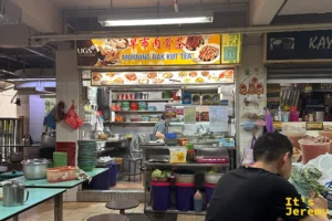 芳林熟食中心一樓的早市肉骨茶攤位，上方掛著黃色中英文燈箱招牌