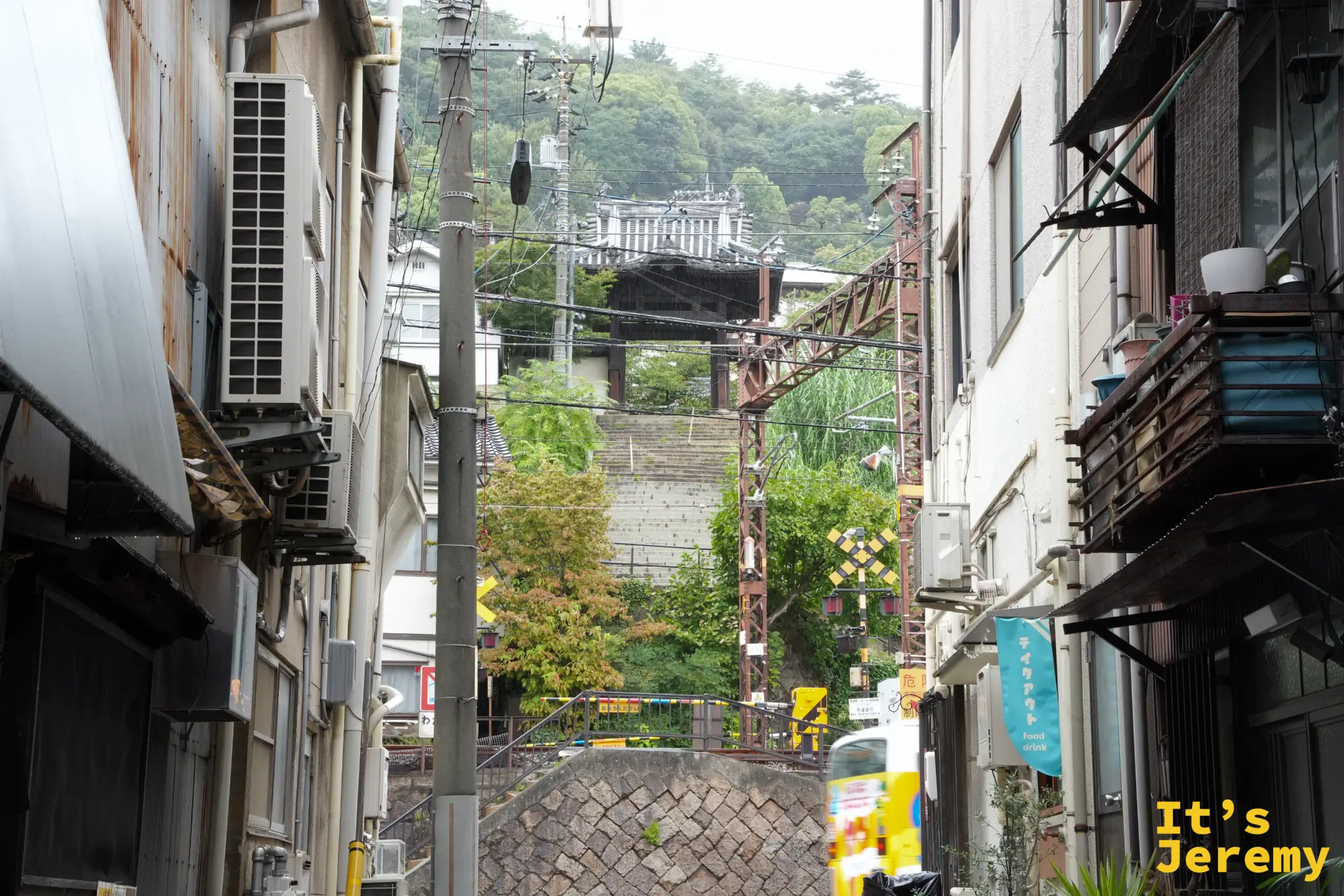 從巷弄望出去是山崖上的寺廟與平交道