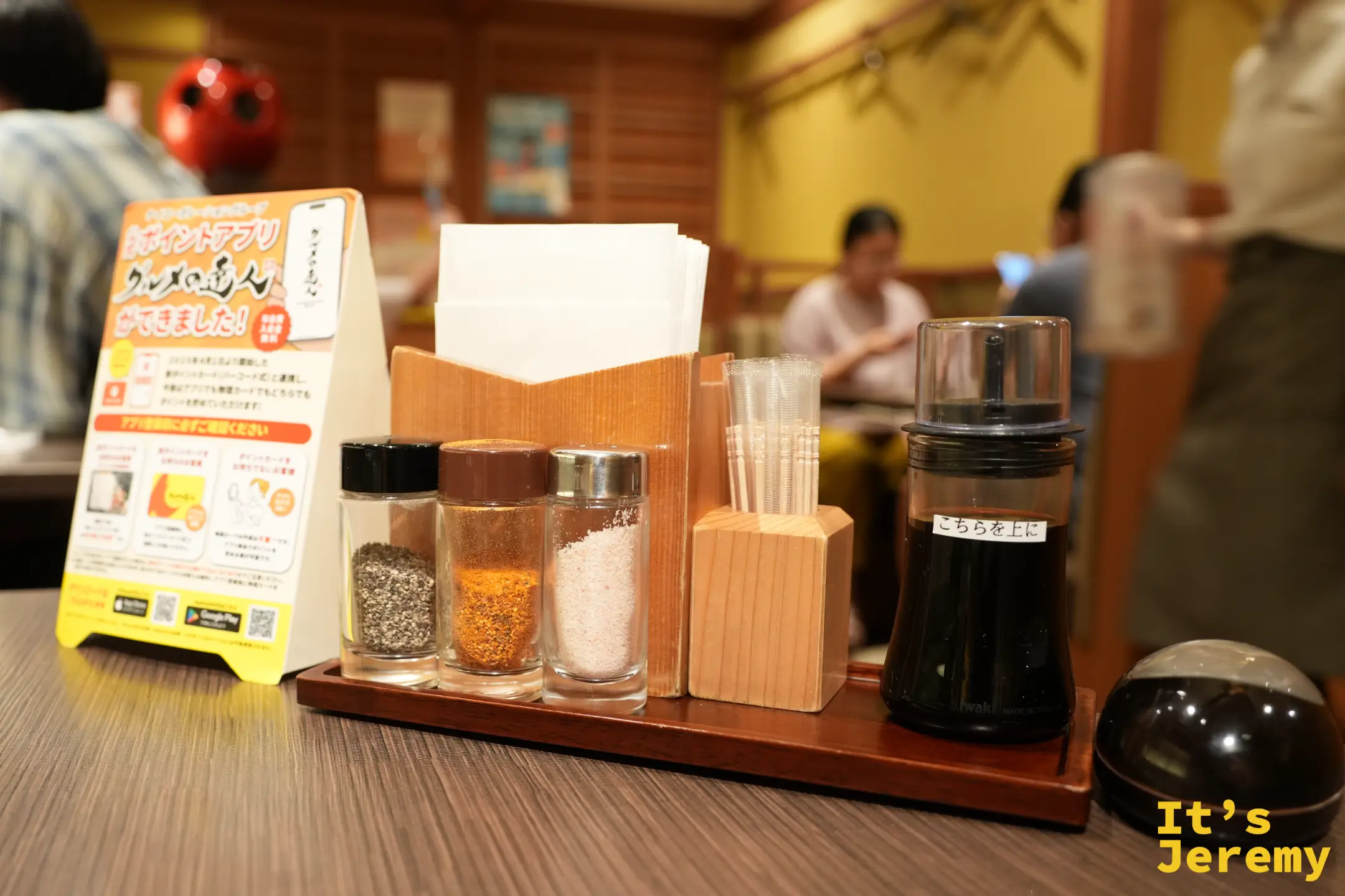 桌上的調味料架，有黑胡椒、辣椒粉、鹽和醬油
