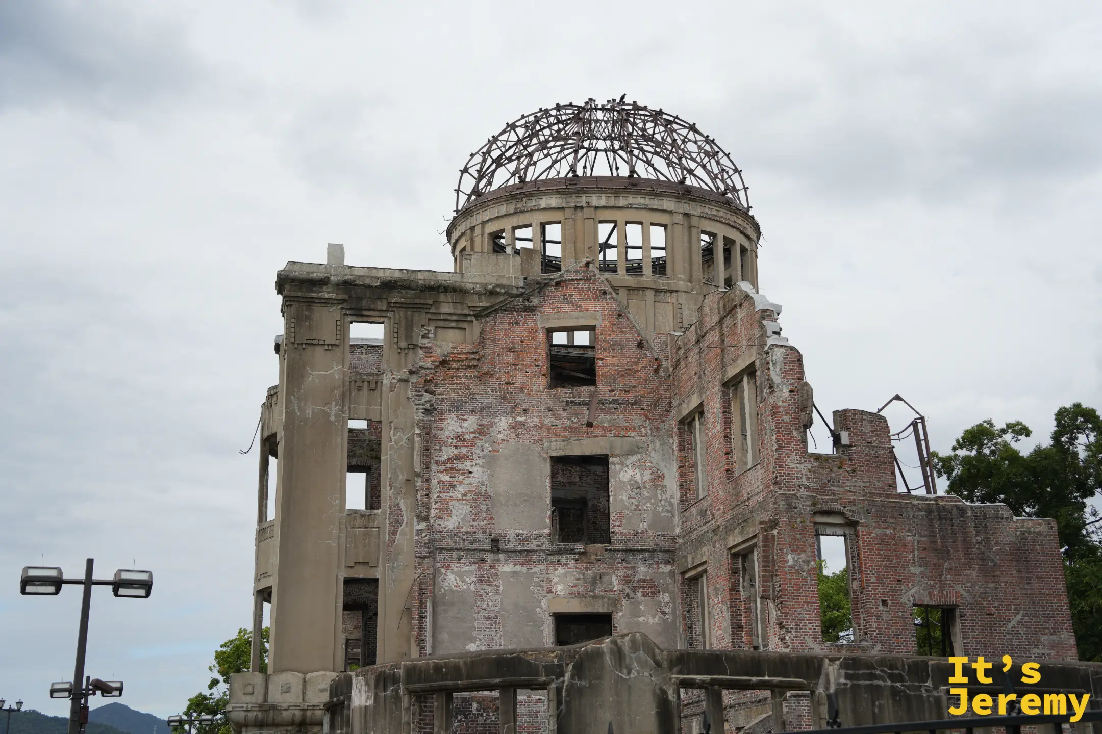 從公園望向原爆圓頂館，頂部只剩鋼骨的圓頂與斑駁的外牆