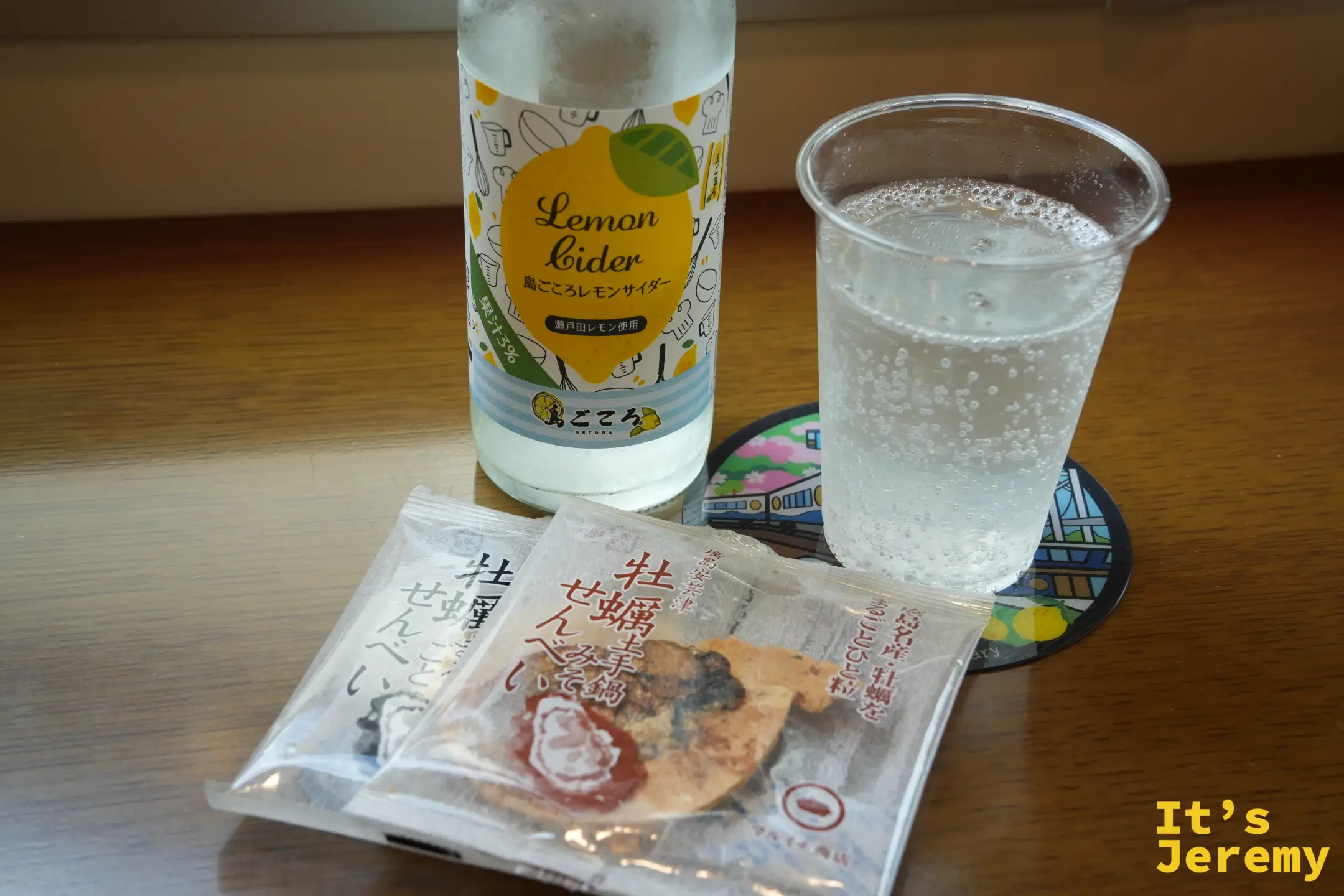 檸檬汽水倒進杯裡，旁邊是牡蠣仙貝