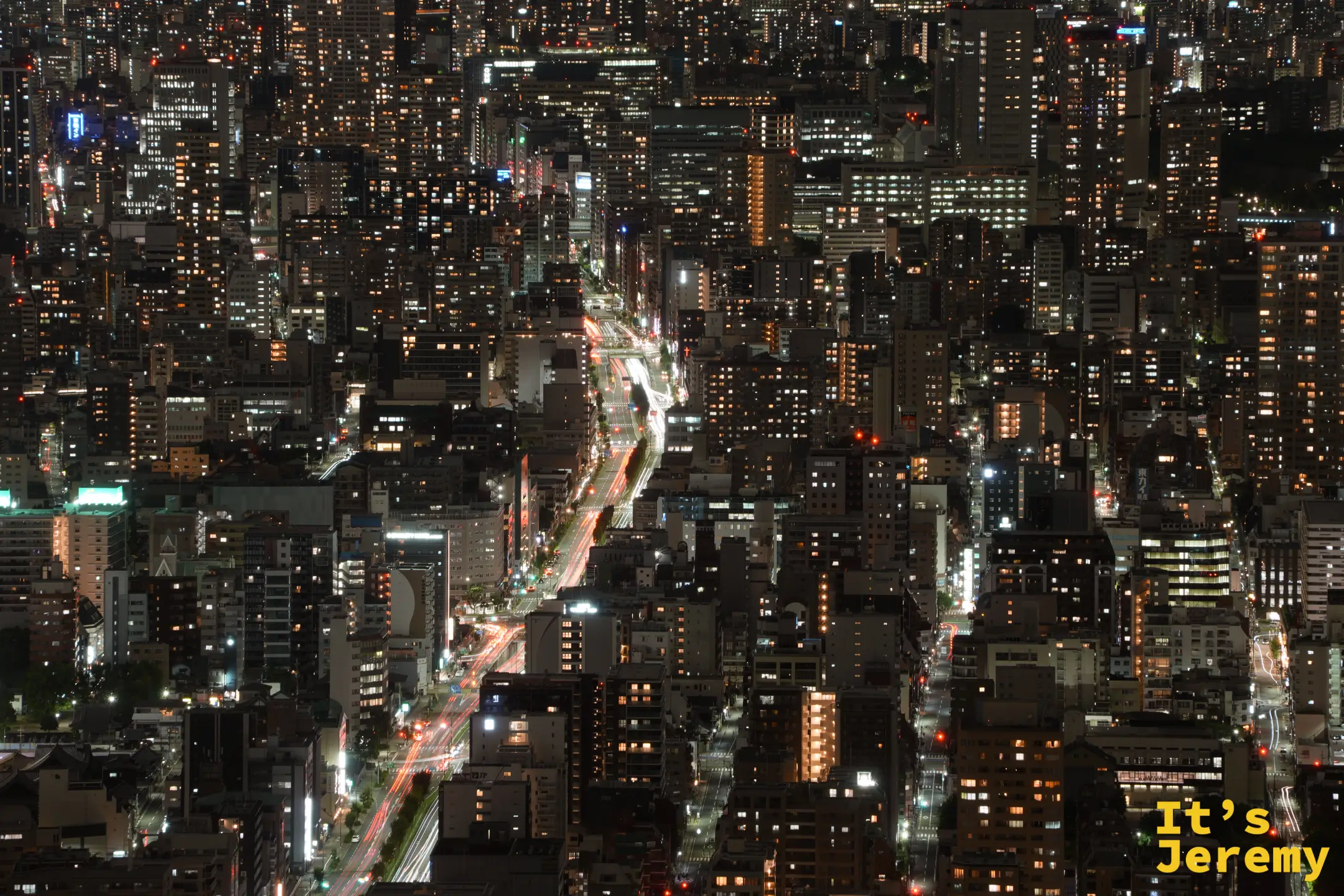 夜晚的大馬路車流光軌穿過大樓之間
