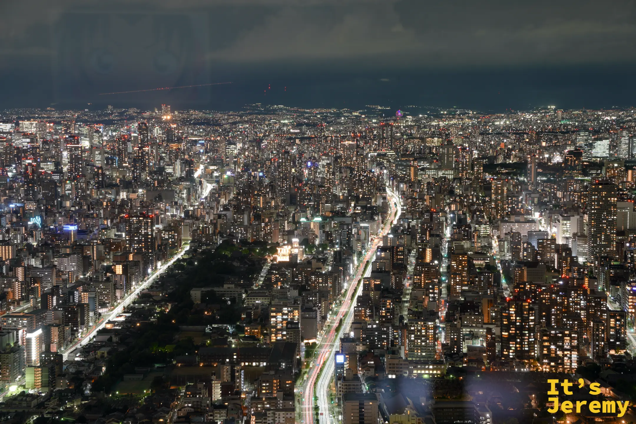 夜晚兩條光軌穿過大阪市區