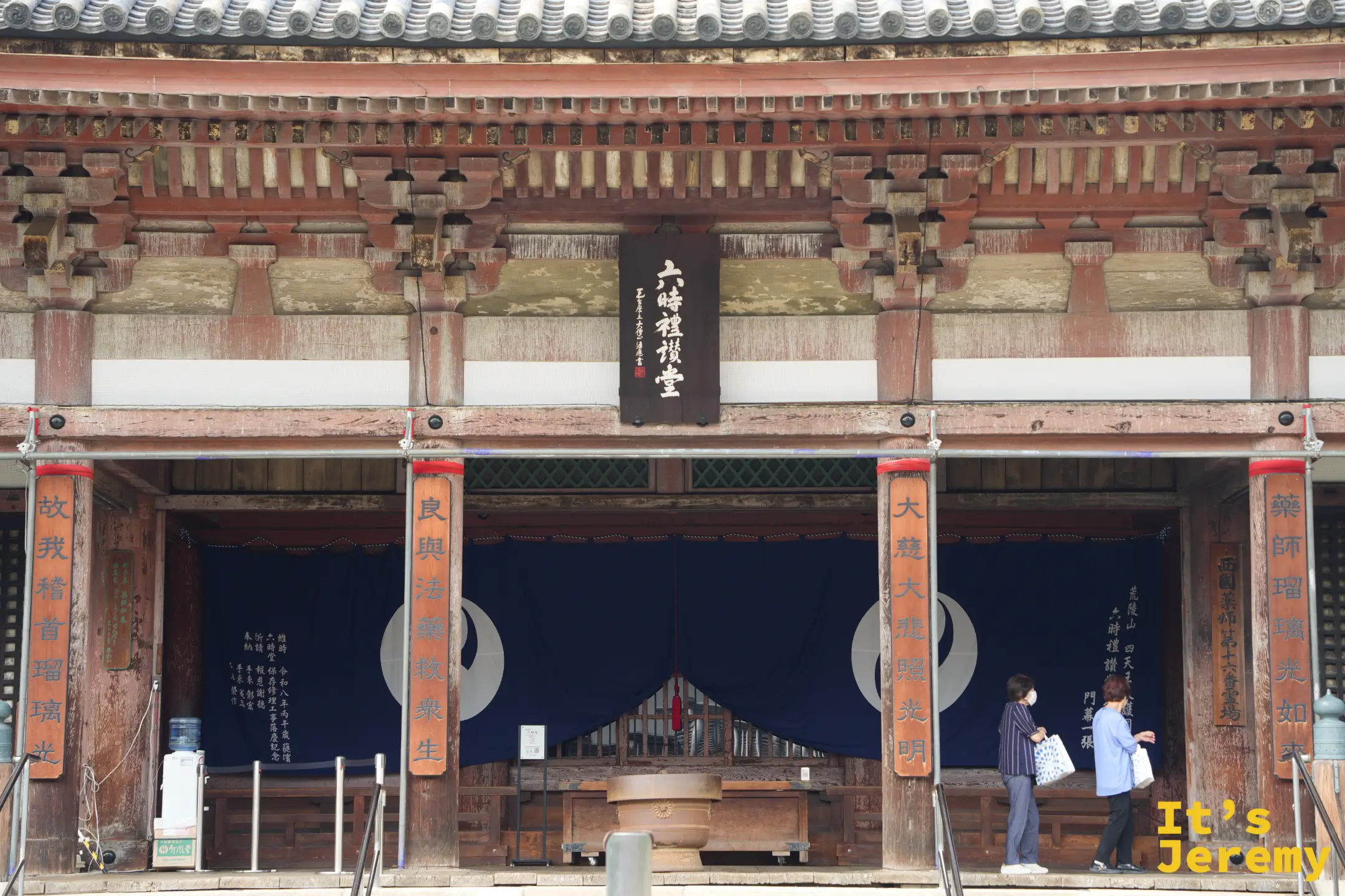 六時礼讃堂堂前，信眾在藍色布幕前參拜