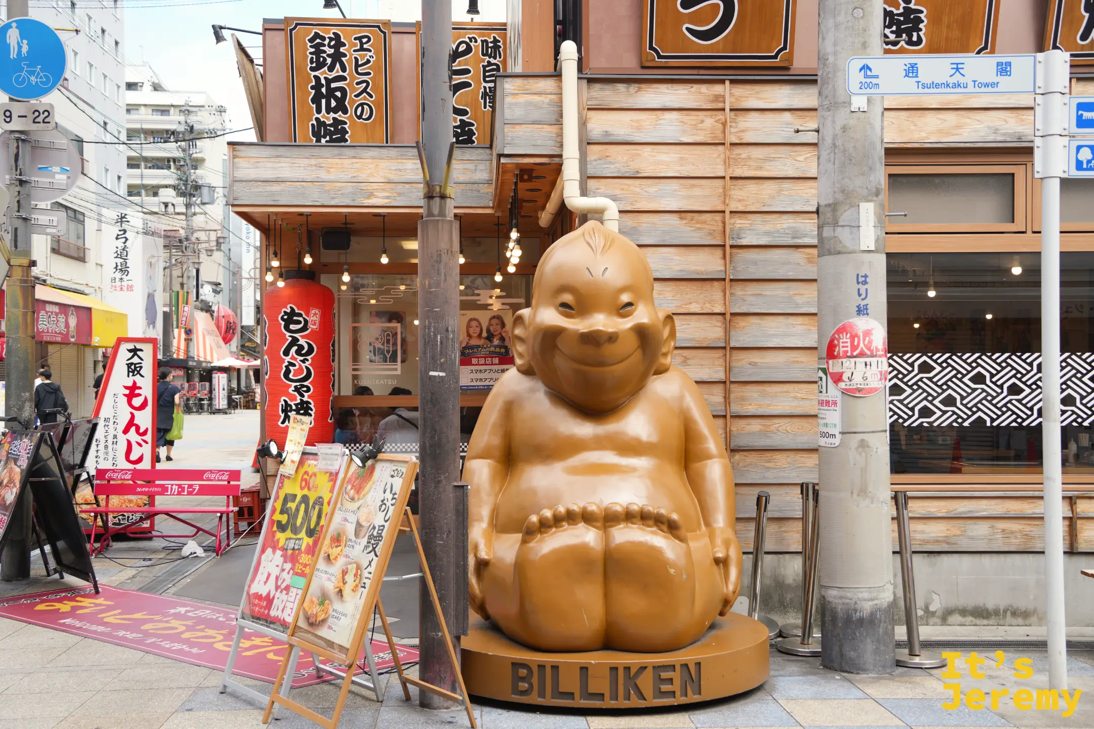新世界街角的比利肯雕像，底座寫著 BILLIKEN