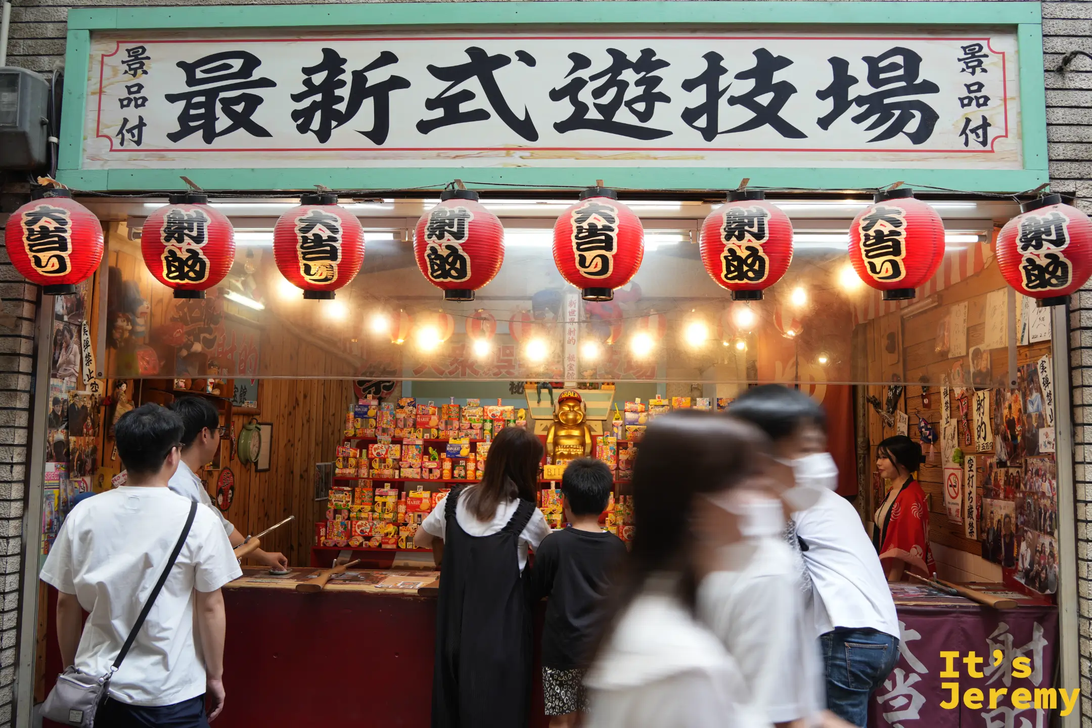 掛著「最新式遊技場」匾額的射的店，門口擠滿遊客