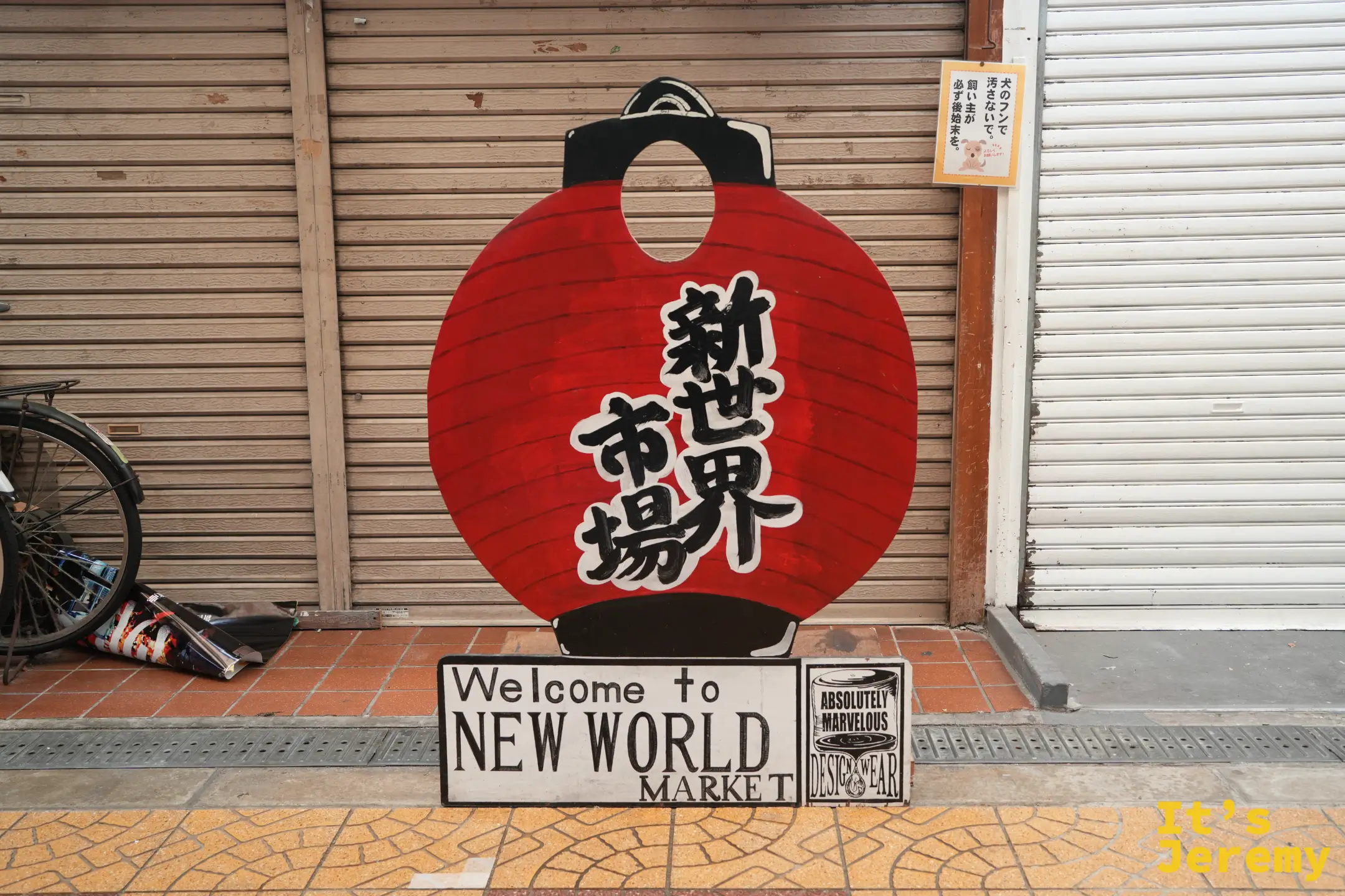新世界市場拉下鐵門前的紅燈籠造型歡迎立牌