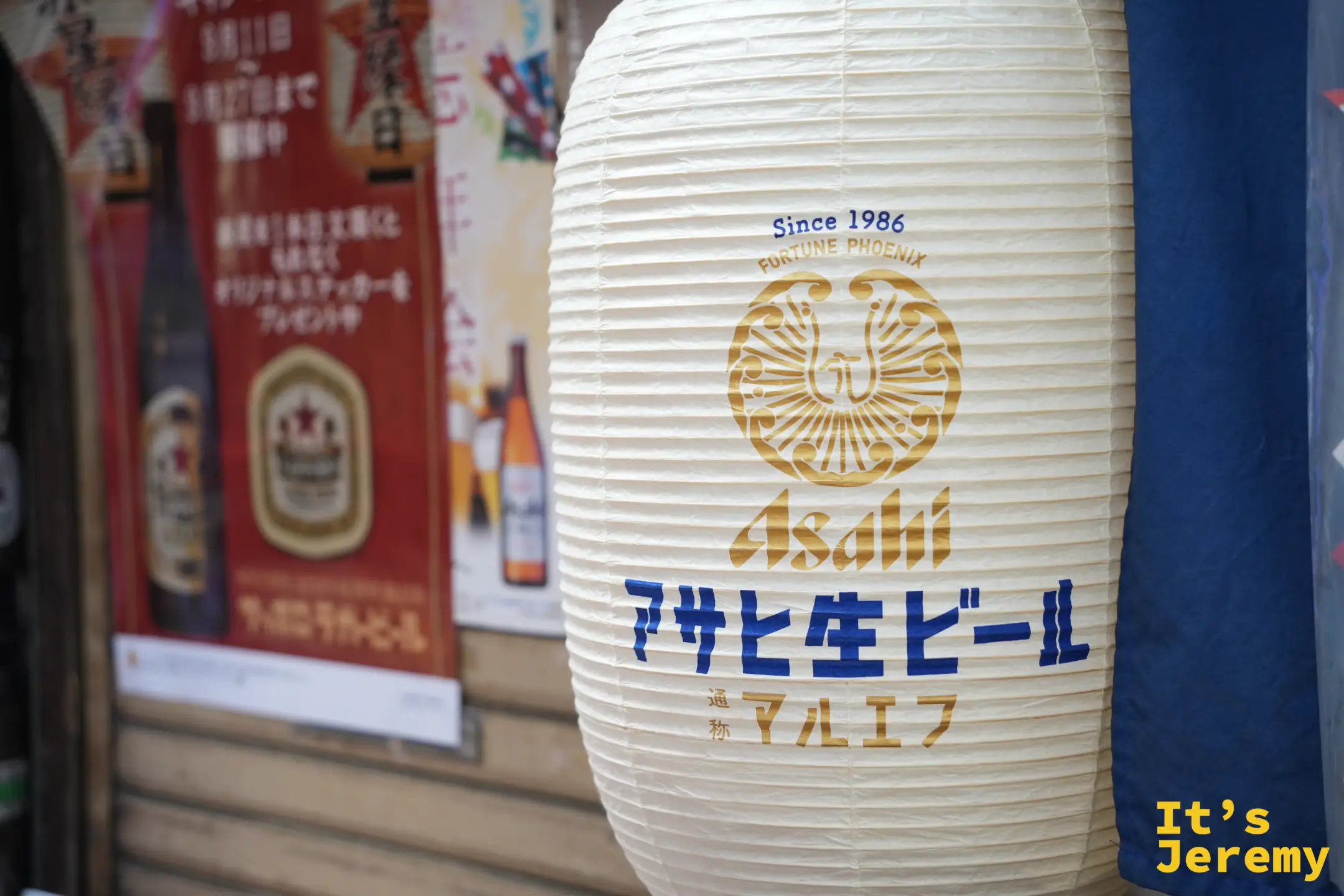 居酒屋門口寫著朝日生啤酒的白色燈籠